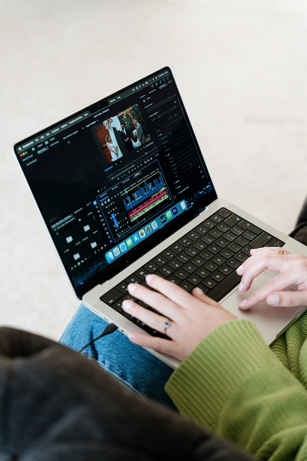 Close-up of a person editing a video on a laptop using video editing software, with a wedding scene visible on the screen.