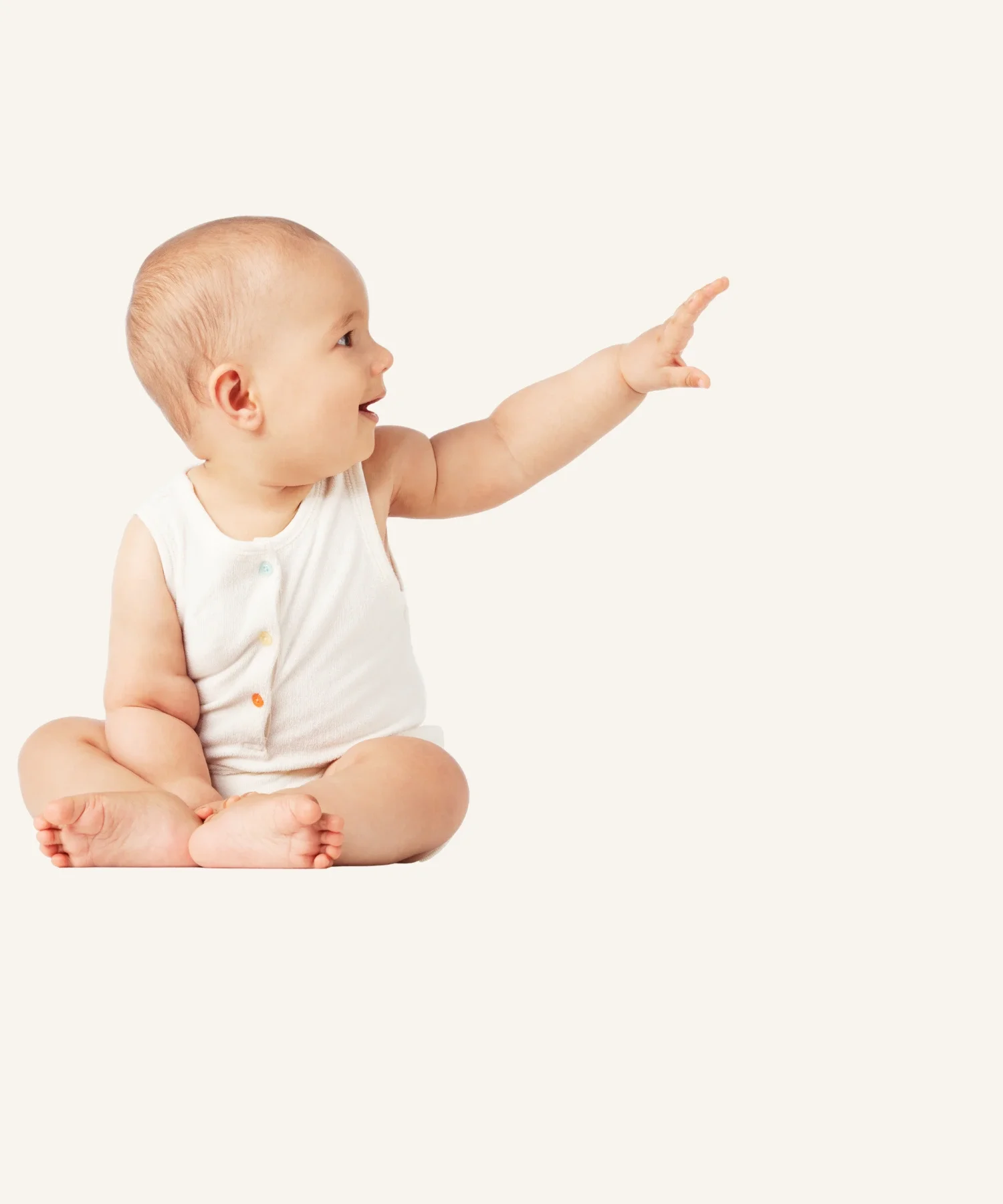 A baby sitting cross-legged pointing to the right with a curious expression.