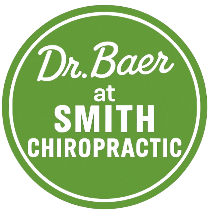 A circular logo with a green background and black border, displaying the text 'Dr. Bauer at Smith Chiropractic' in black, purple, and green fonts.