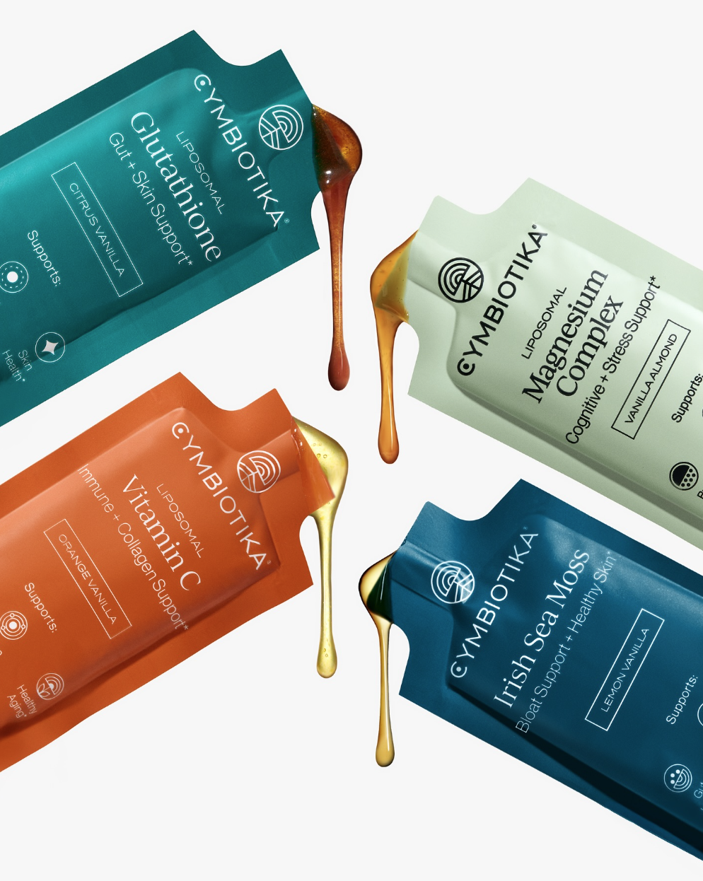 Four colorful sachets of Gymbiotika health supplements with spilled liquid drops, placed diagonally on a white background. The sachets are labeled Glutathione, Magnesium Complex, Vitamin C, and Irish Sea Moss.