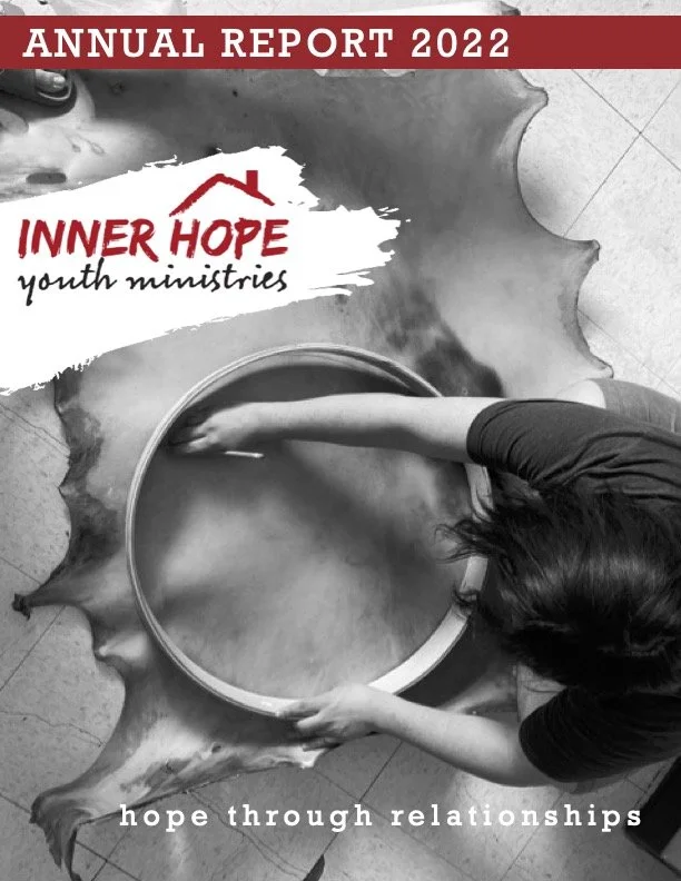 A person standing and reaching into a large metal bowl on the ground. The cover features text: "Annual Report 2022," "Inner Hope Youth Ministries," and the tagline "hope through relationships."