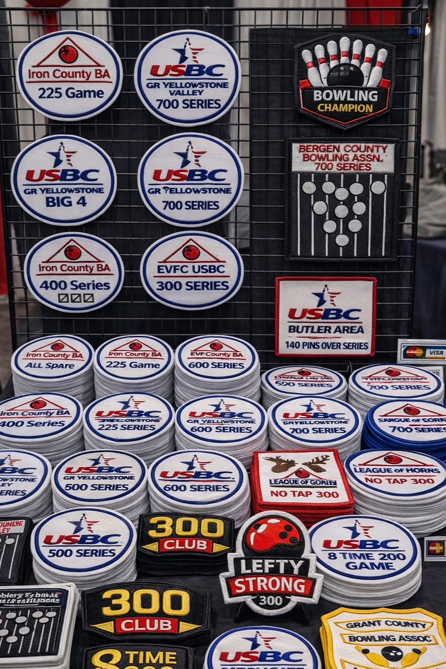 Collection of bowling patches and patches with various series and team names, including Leiter County BA, USBC Yellowstone, Bergen County Bowling Assn., and League of Gorns, displayed on a wire grid.