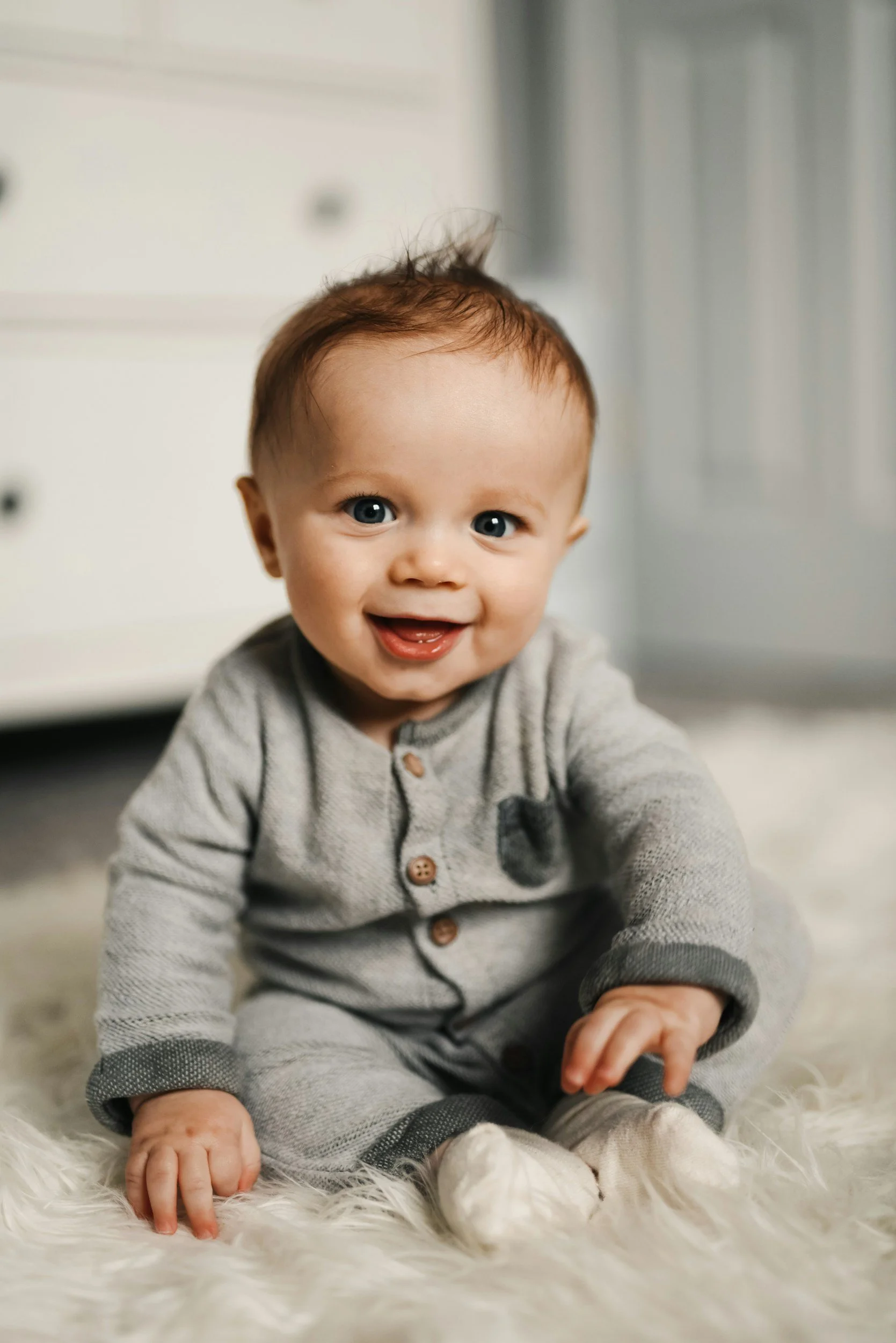 Lachendes Baby auf flauschigen weißen Teppich : Ein Einblick in die Potenzialerkennung und Talentsichtung durch professionelles Face Reading für Babys.