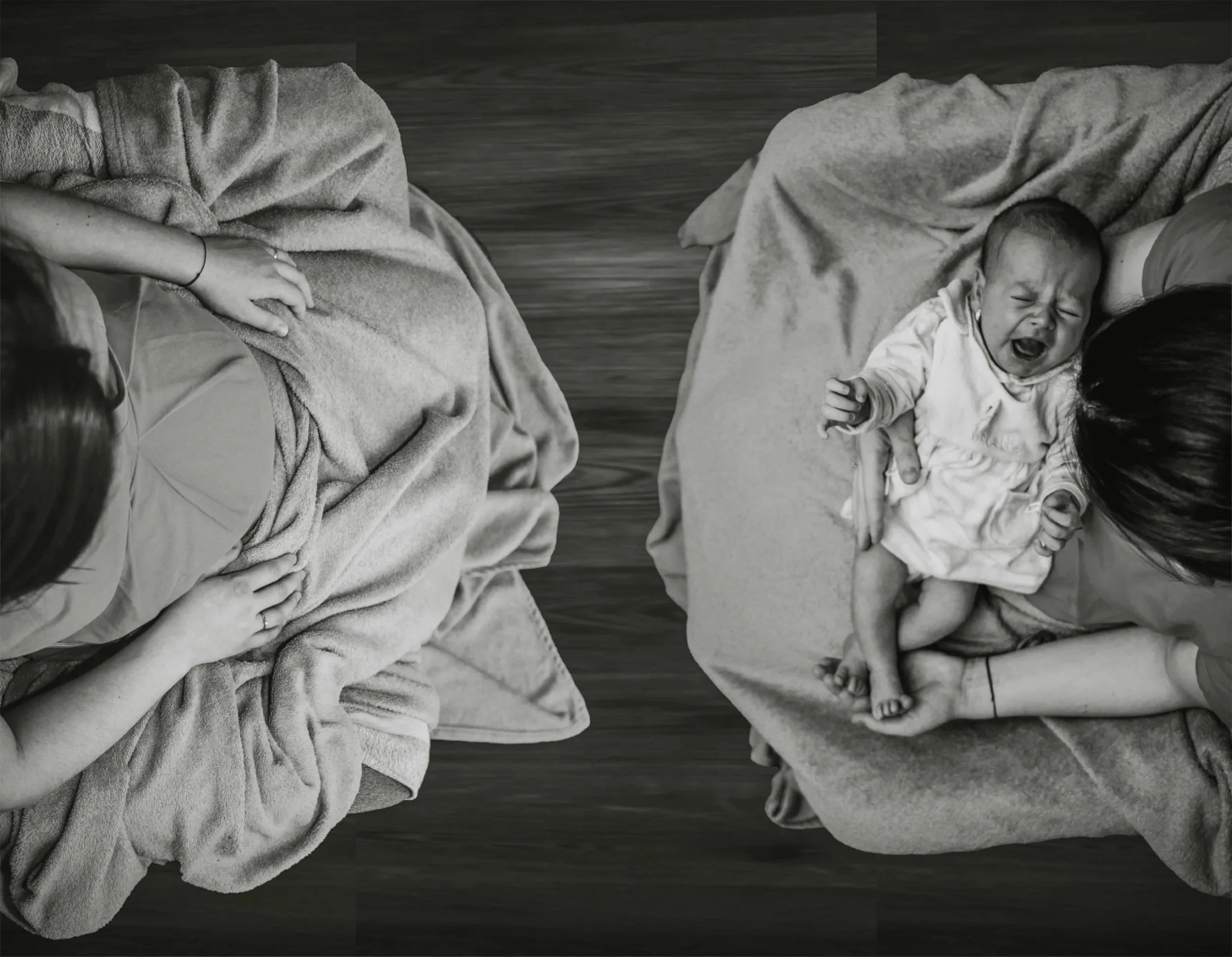 Two people facing each other, one is pregnant and one has a newborn on their lap.