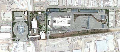 Satellite image of an urban area showing buildings, roads, parking lots, and railroad tracks.