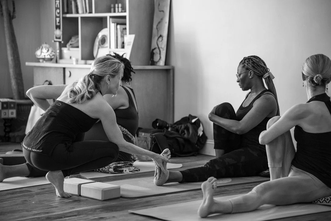 Pamela Meriwether adjusting a student in yoga class