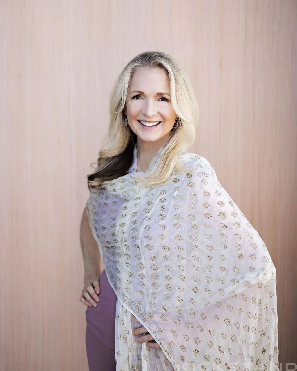 Pamela wrapped in  a white sari with gold pattern.