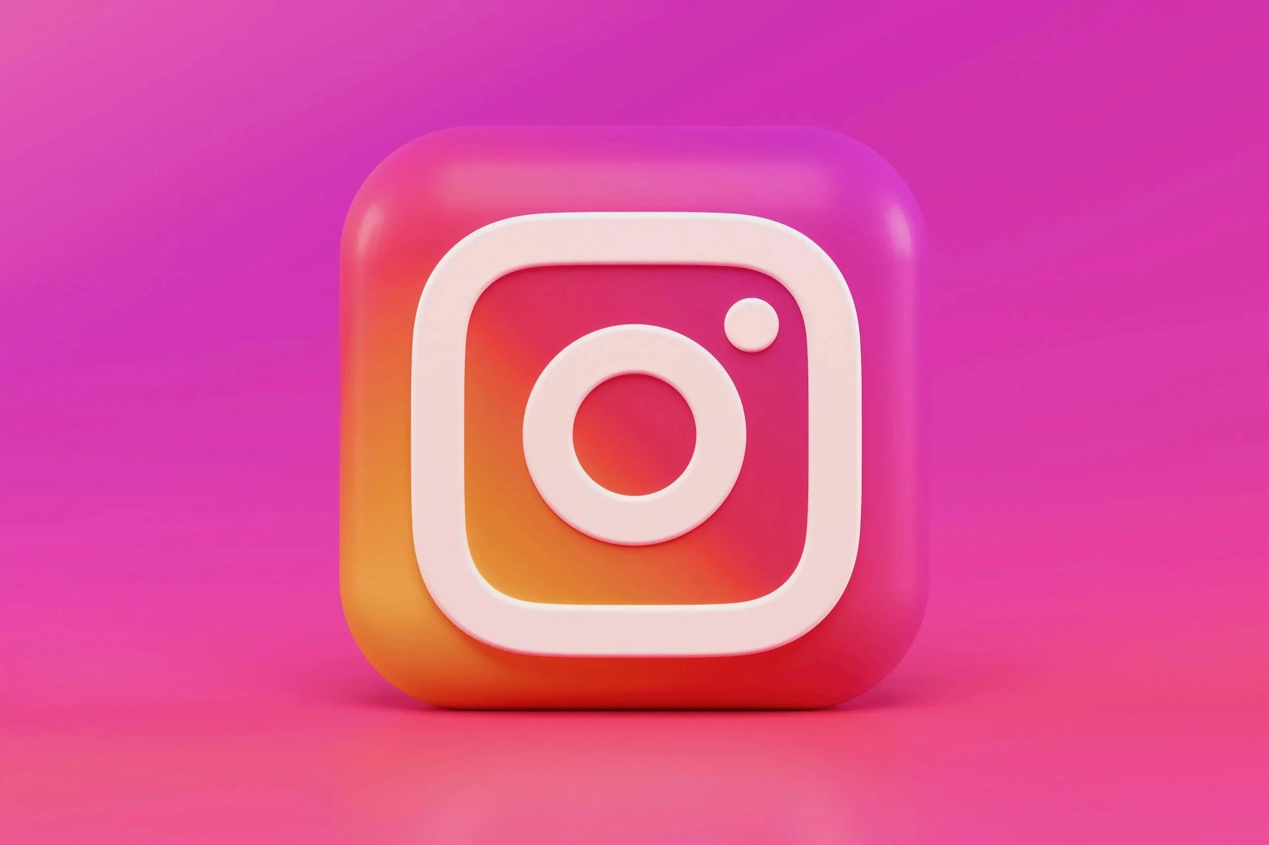 3D icon of the Instagram logo with a white camera outline on a pink, orange, and purple gradient background.