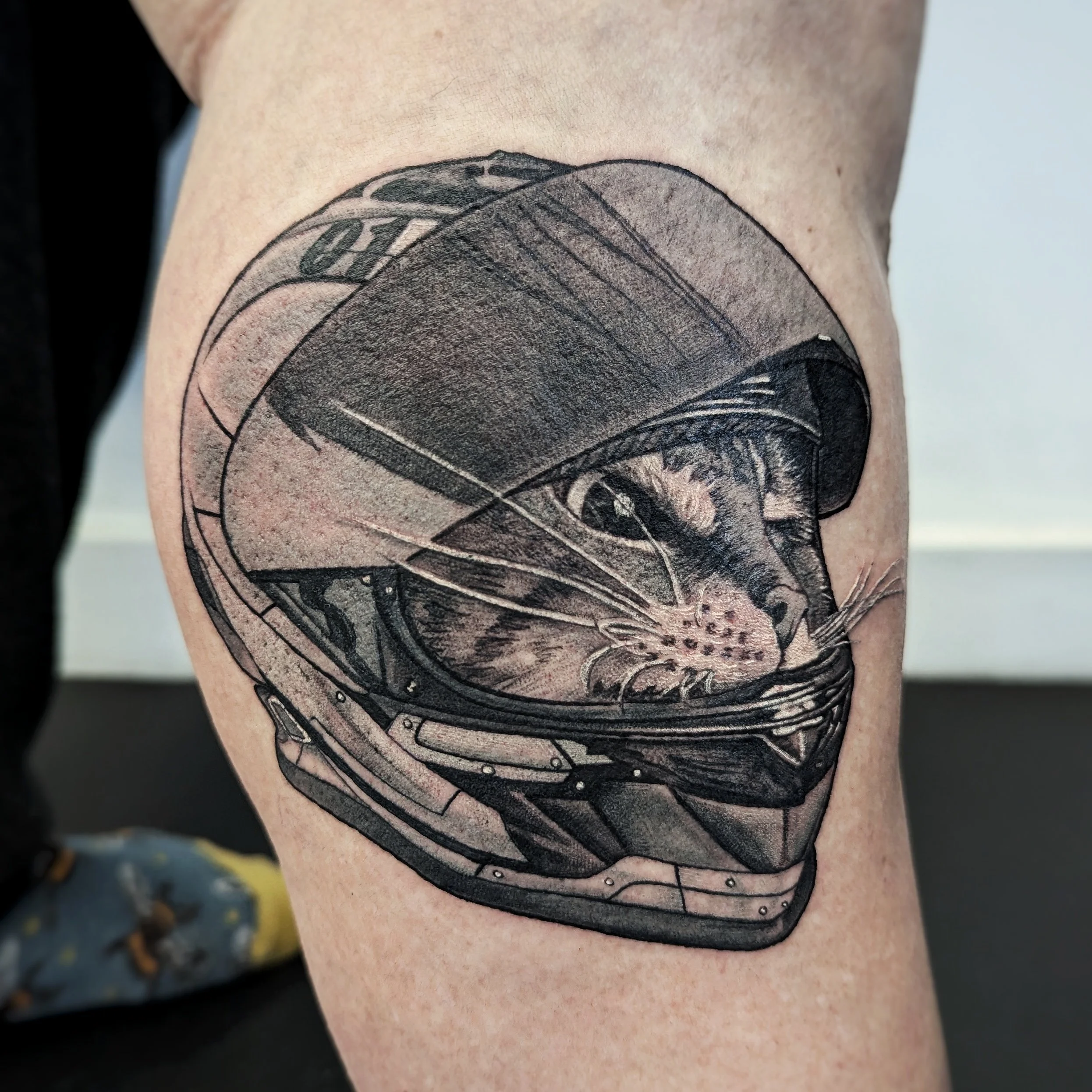 Black and gray tattoo of a yin-yang symbol on a person's upper arm.