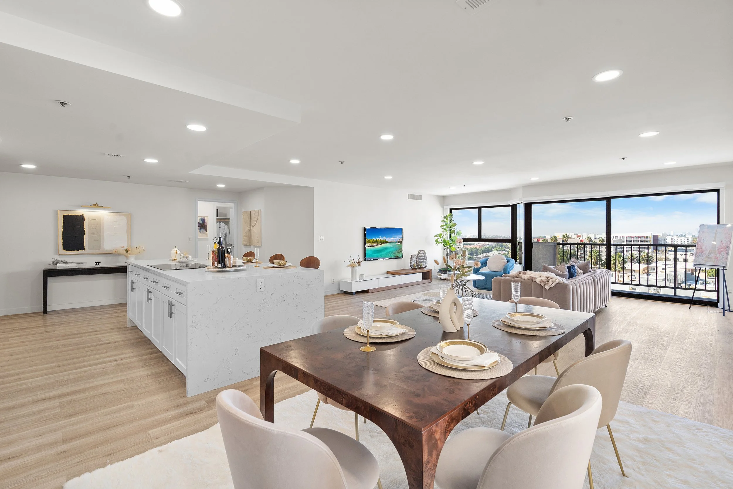 Modern open-plan living room and dining area with large windows, cityscape view, and contemporary furniture.