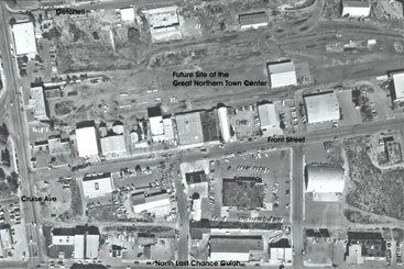 A black-and-white aerial map showing an urban area with streets, buildings, and labels indicating future site planning and nearby landmarks.