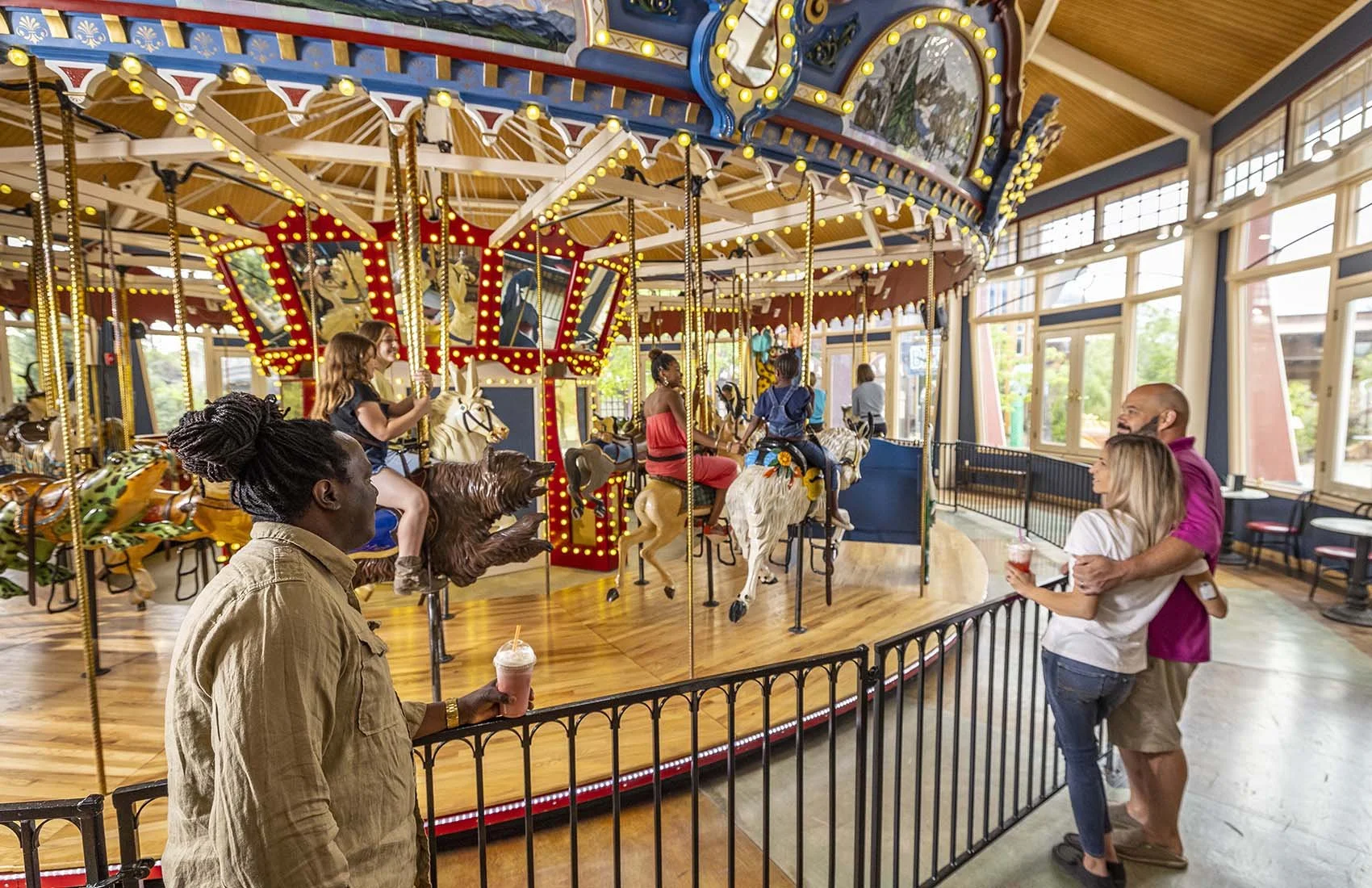 People enjoying a ride on a carousel inside an amusement park.