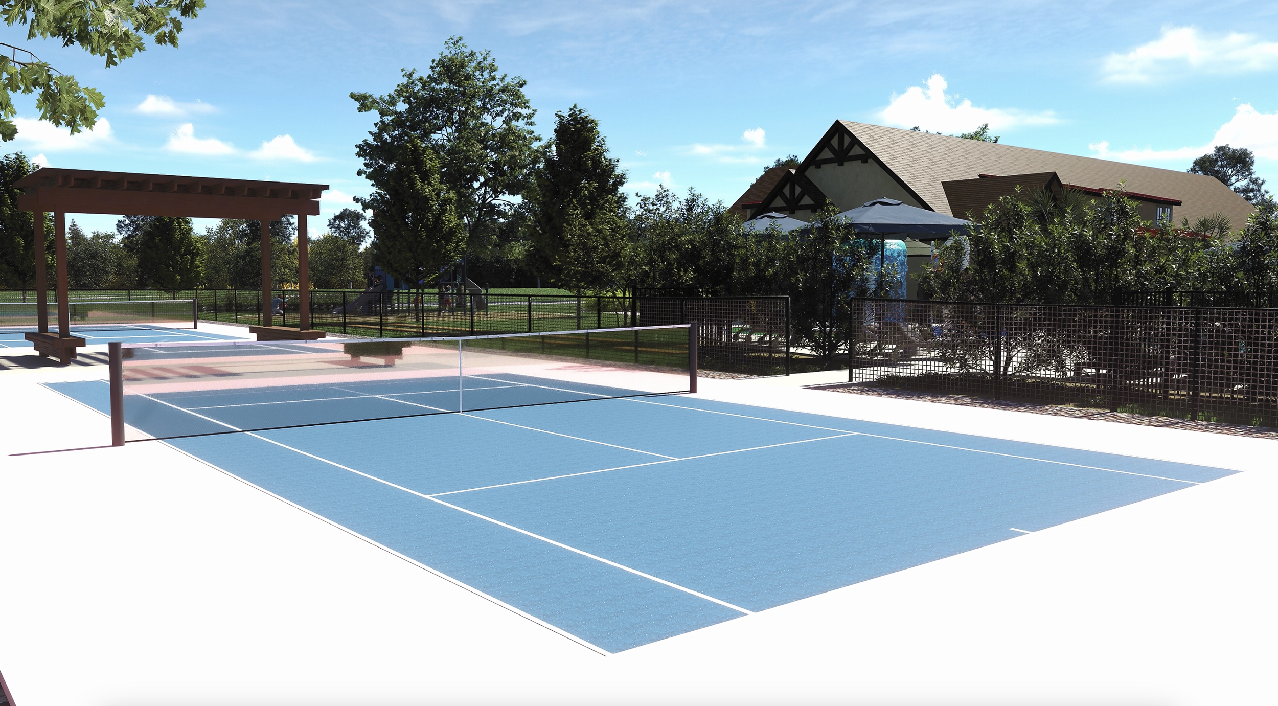 An empty outdoor tennis court with blue playing surface, white lines, and a net, surrounded by a black fence, with trees, houses, and a clear blue sky in the background.