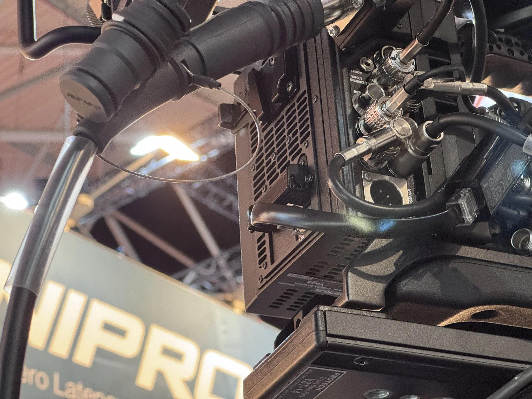 Close-up of a computer hardware component with multiple cables connected, partially obscured by a yellow label with black text.