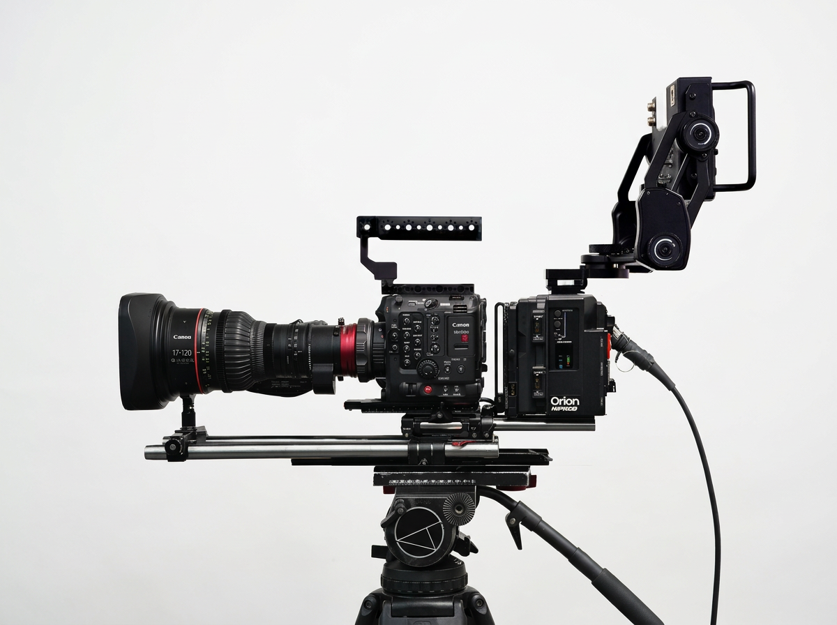 Professional cinema camera mounted on a tripod with various attachments, including a large lens, follow focus system, and electronic accessories, set against a plain white background.
