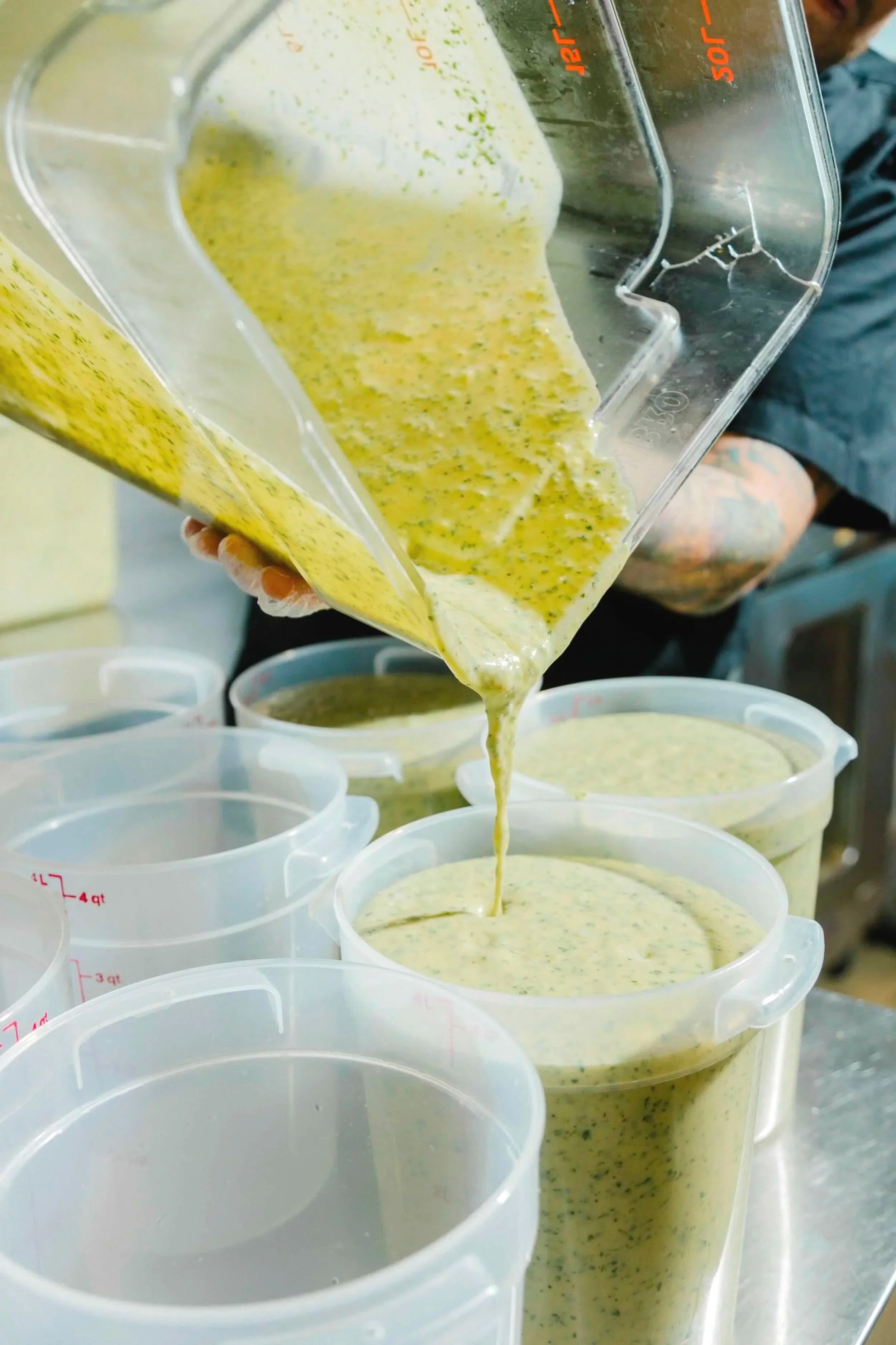 Fresh batch of cilantro lime being poured into gallon containers at our prep kitchen