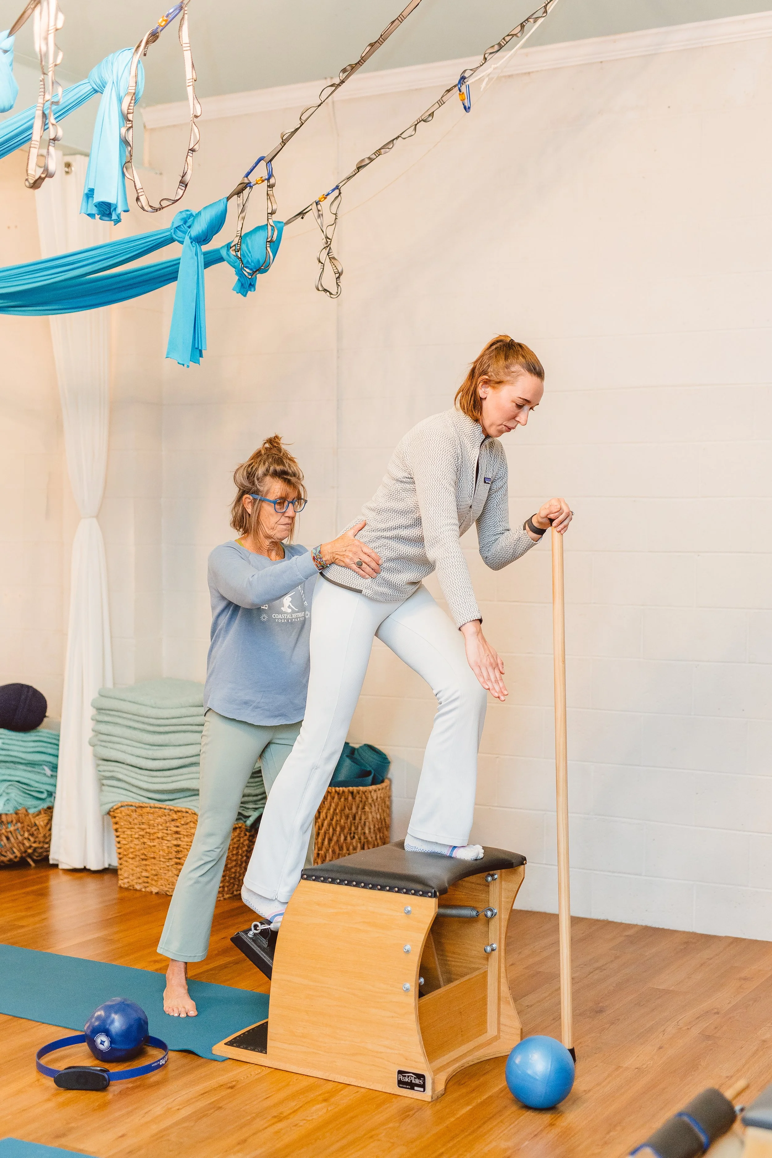 Reformer Pilates session at Coastal Retreat Studios in Easton, MD — instructor guiding a client through standing reformer work in a small-group class