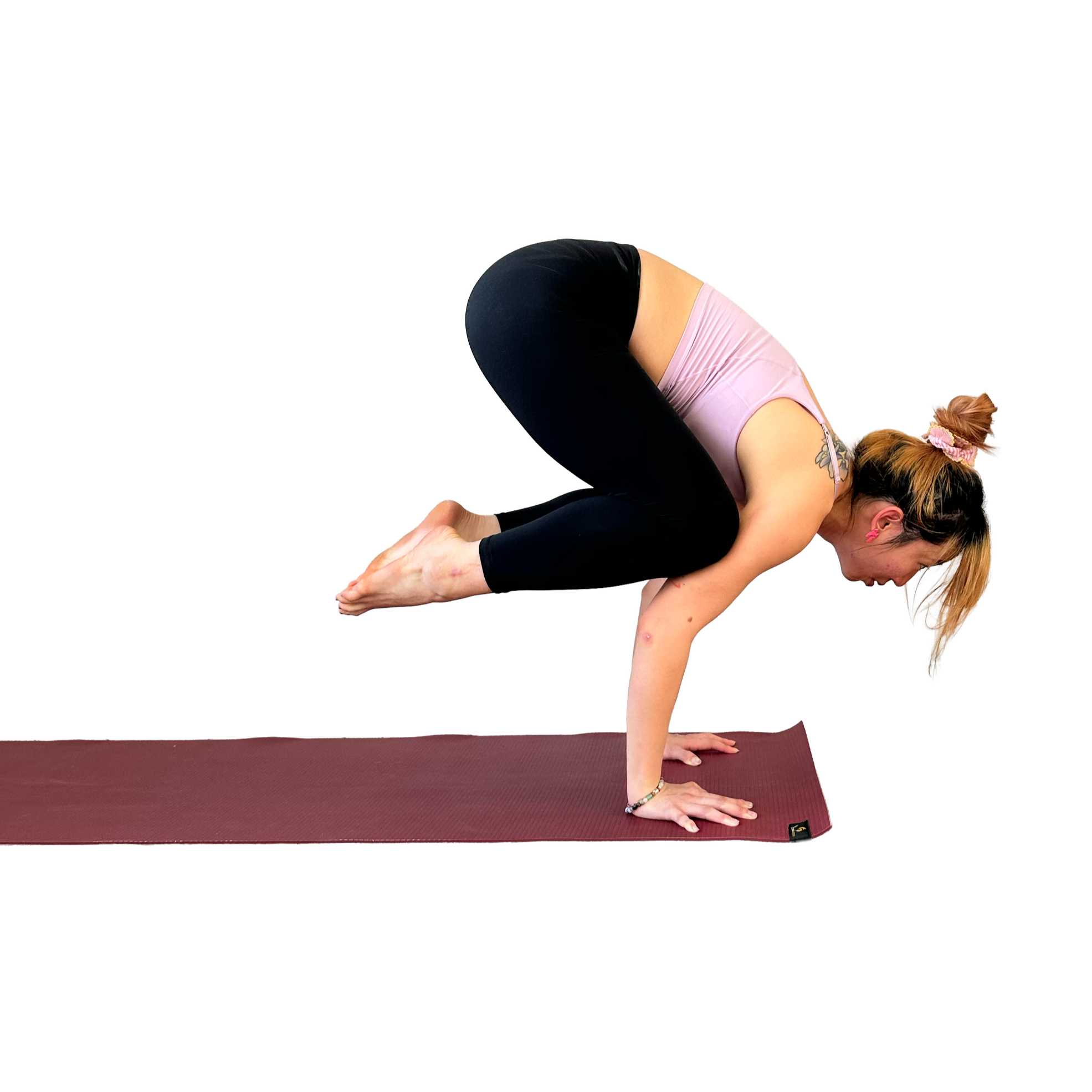 Woman practicing yoga in an advanced pose on a yoga mat.