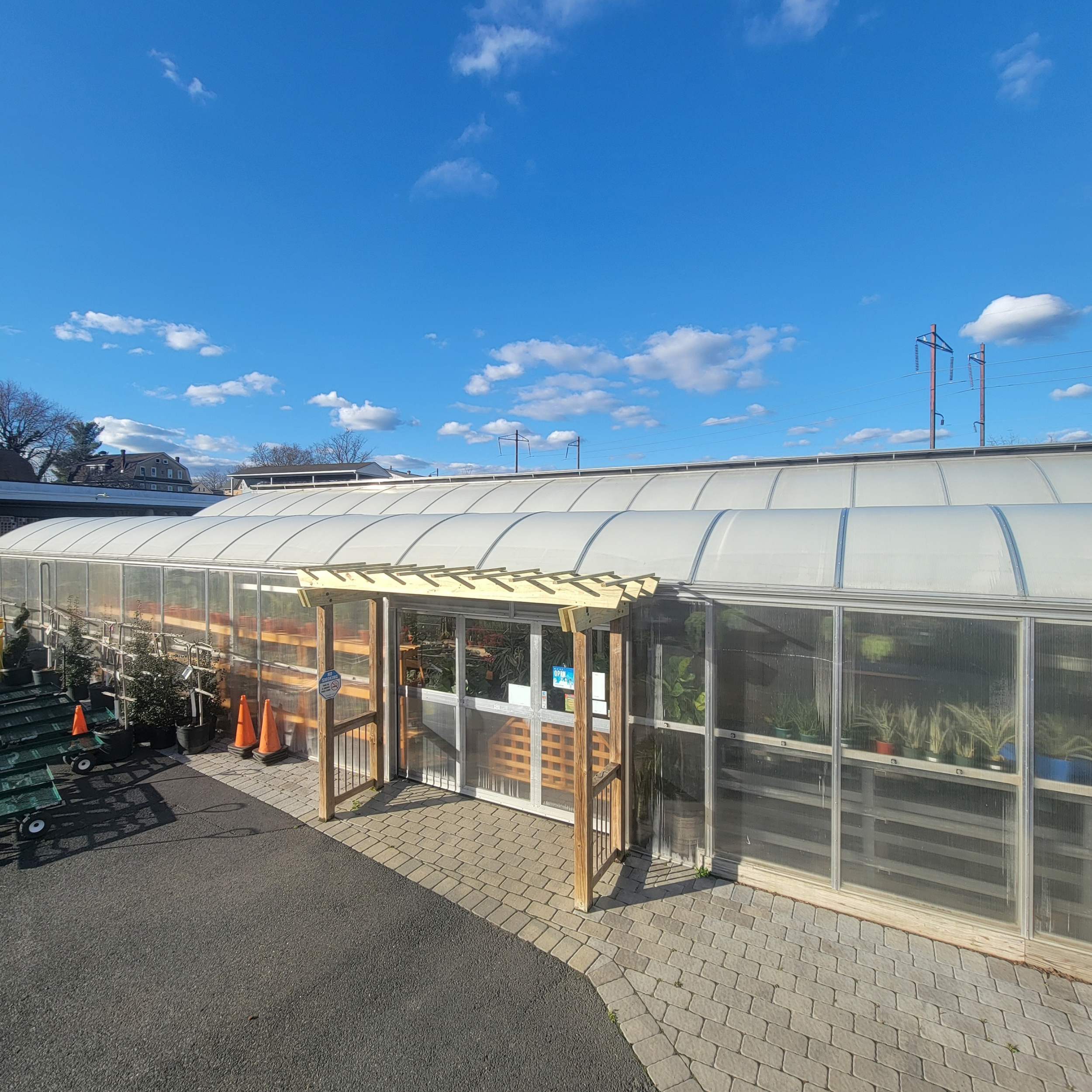 Side door of greenhouse with new pergola covering the entryway.