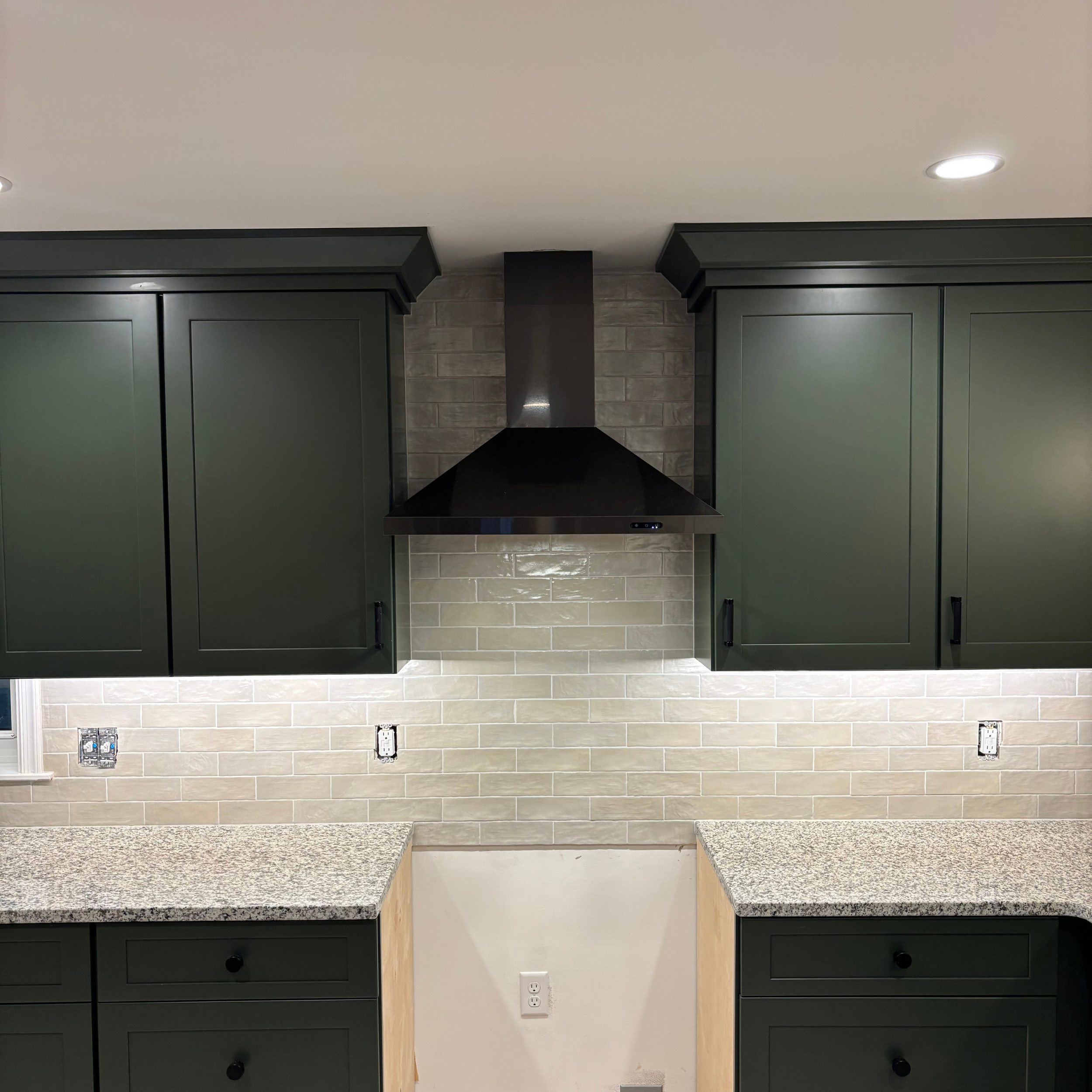 Tile-work shown cut to fit around kitchen ventilation hood.