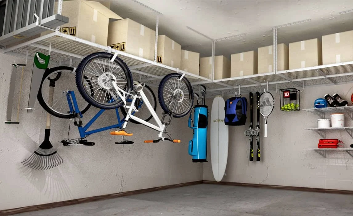 Garage with organized sports equipment including a bicycle, surfboard, skis, tennis racket, and racks of helmets and sports gear.