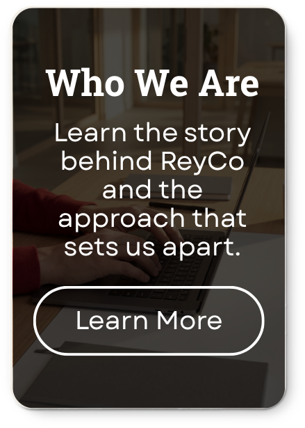 A promotional graphic with the text 'Who We Are. Learn the story behind ReyCo and the approach that sets us apart.' There is a button labeled 'Learn More.' The background shows a person working at a desk with a laptop.