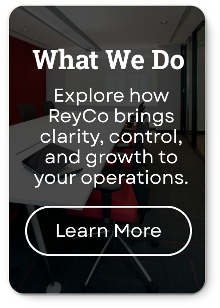 A mobile phone screen displaying a promotional message about ReyCo's services, with a background image of a modern conference room with chairs and a table.