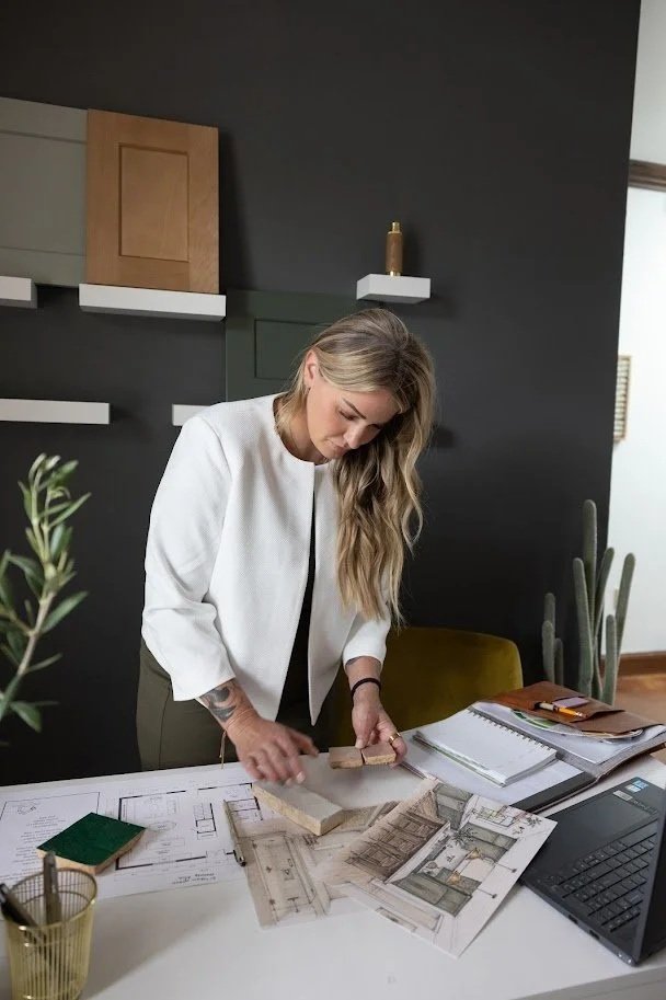 Woman working on architectural plans at a desk in an office.