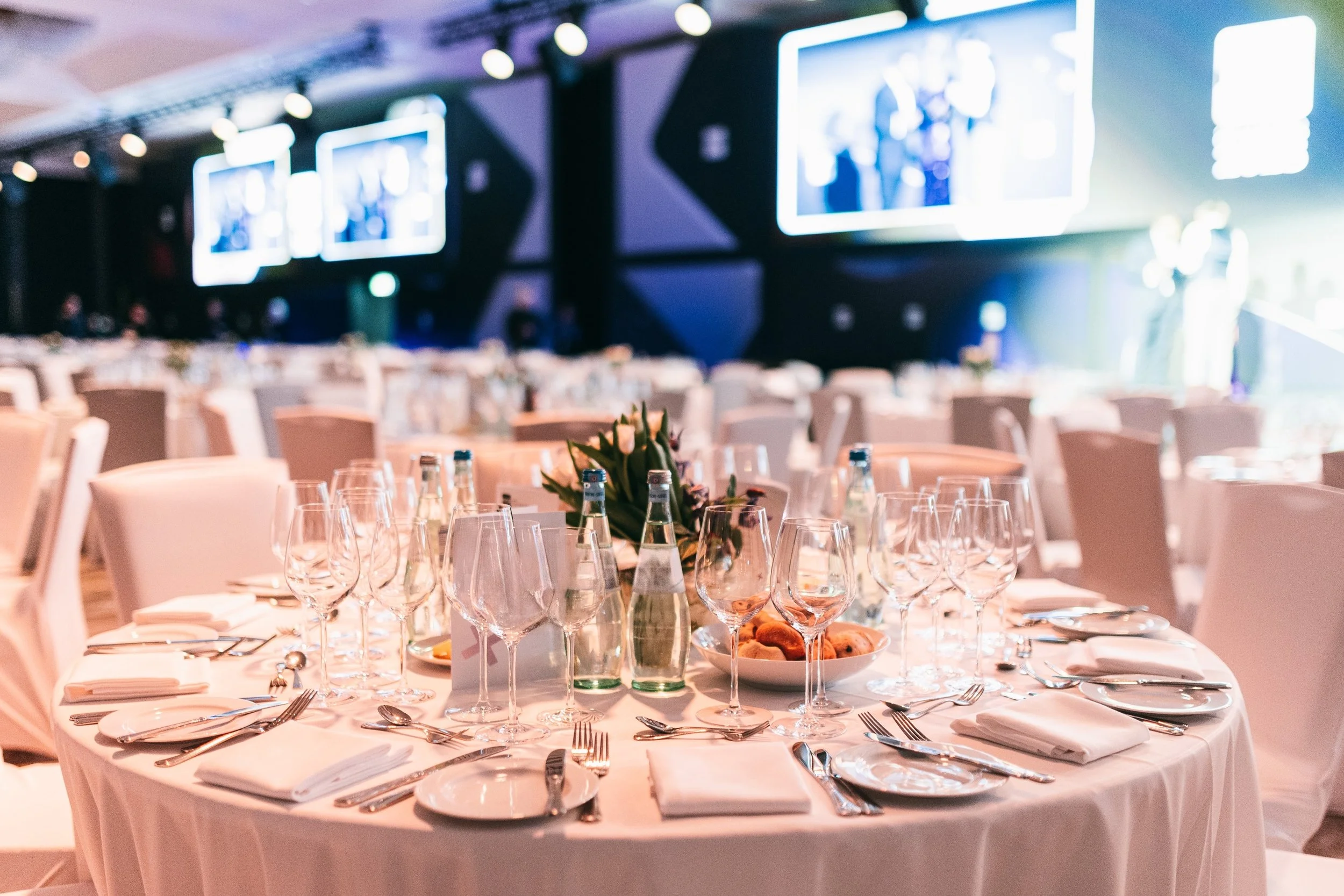 Elegant gedeckter Veranstaltungssaal mit stilvoller Tischdekoration und modernem Ambiente für exklusive Hochzeiten und Events.