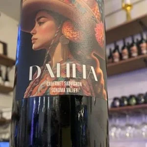 Close-up of a wine bottle label featuring a woman in traditional attire with the word 'DAHLIA' and the description 'Caberent Sauvignon Sonoma Valley'.