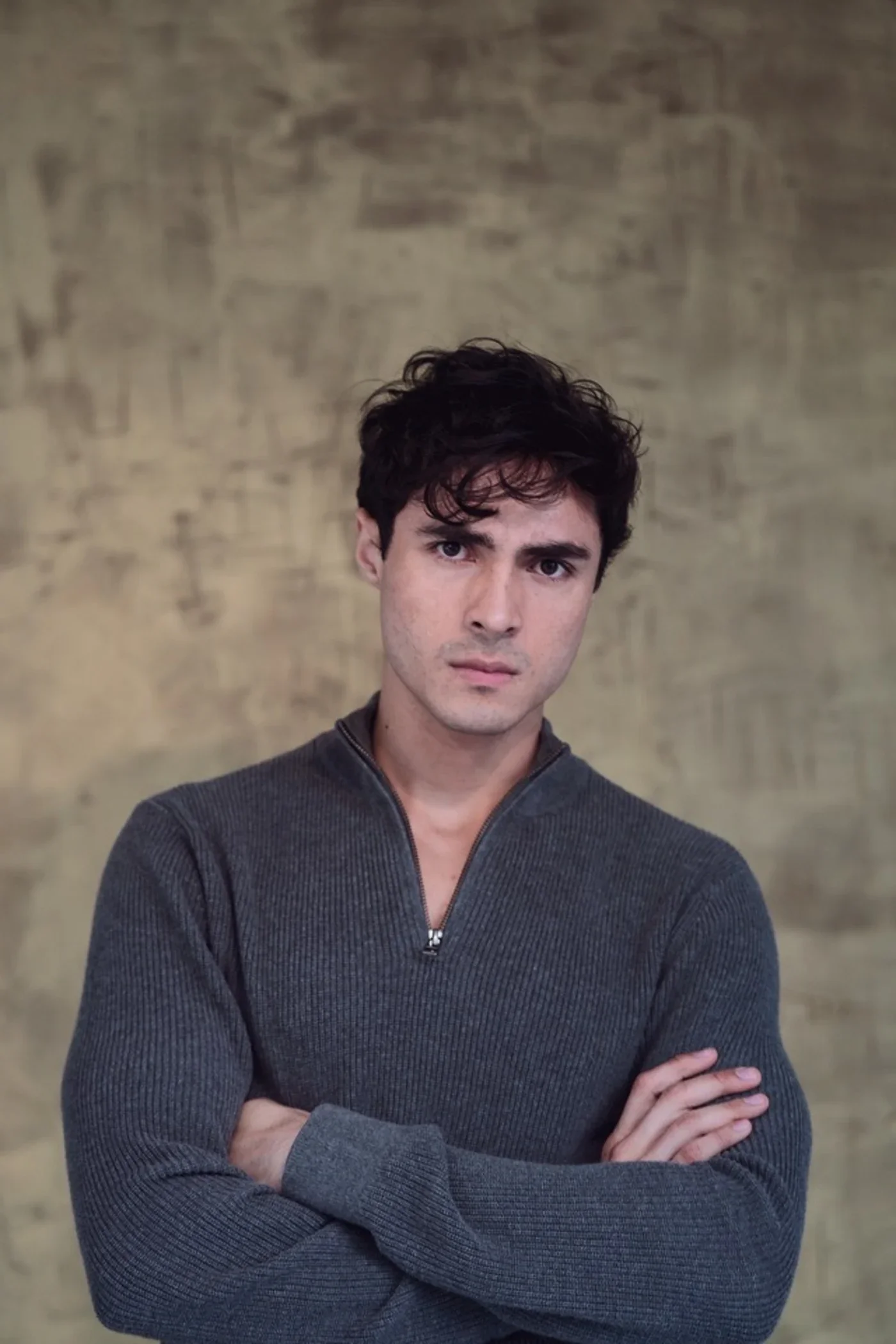 Luis del Toro actor portrait with serious expression wearing grey sweater