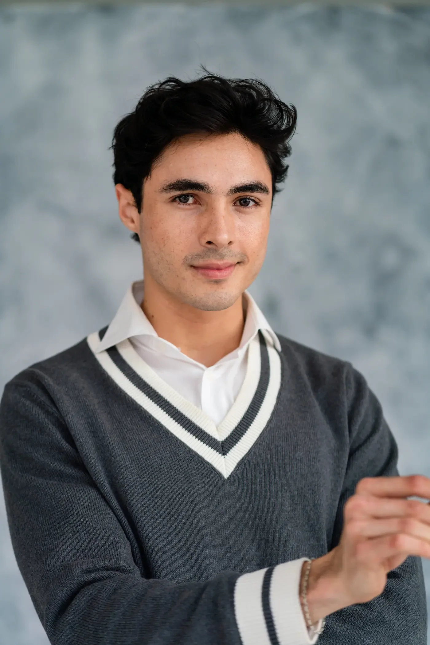 Luis del Toro actor portrait smiling wearing grey sweater and white shirt