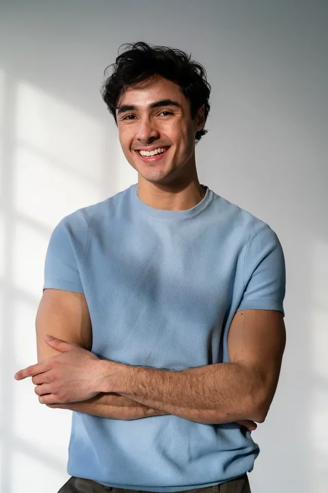 Luis del Toro actor portrait smiling wearing blue shirt against white background