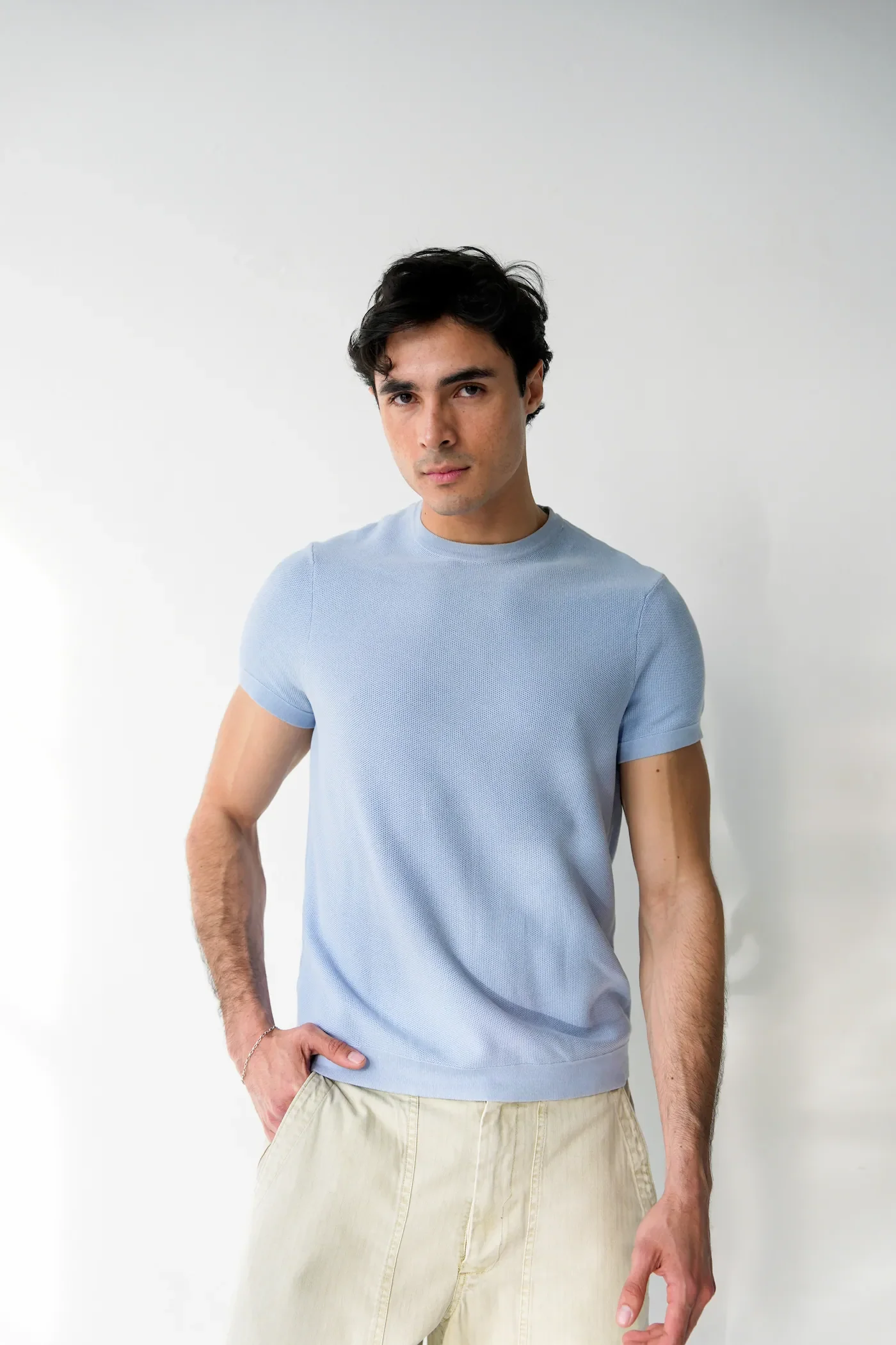 Luis del Toro actor full body portrait wearing light blue shirt against white background
