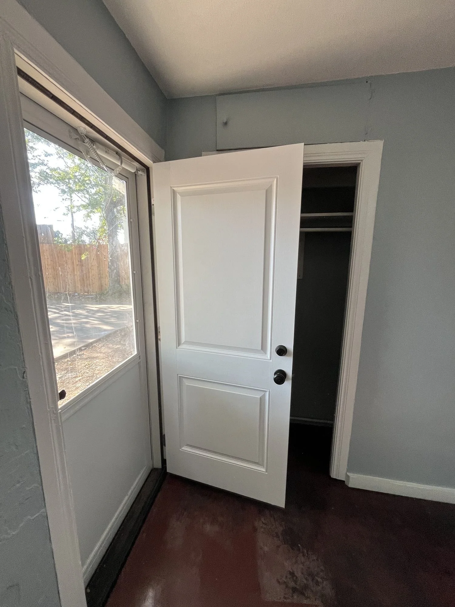 White two-panel door and white casing beside light blue painted walls