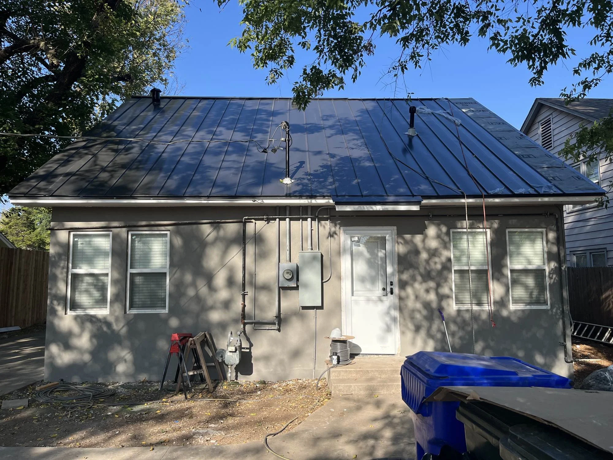 Exterior view of the Norman property showing a white entry door and windows