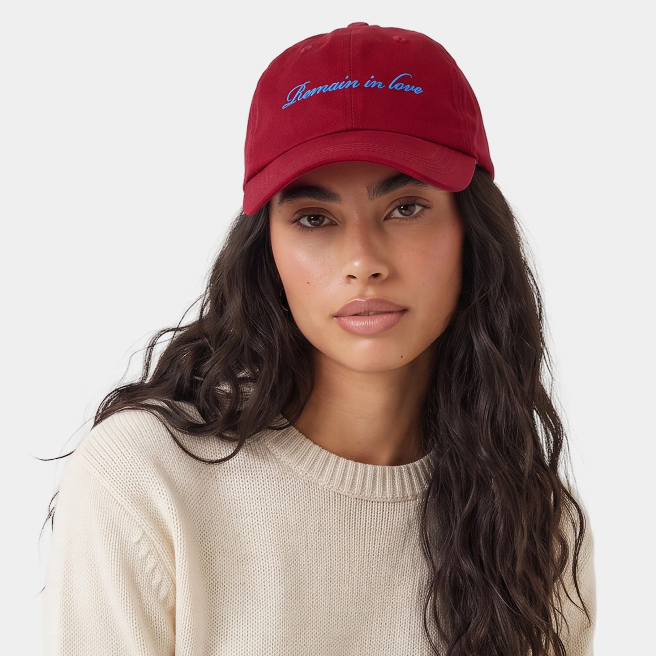 Model wearing the Fruit & Form Remain in Love red cap with blue embroidery.