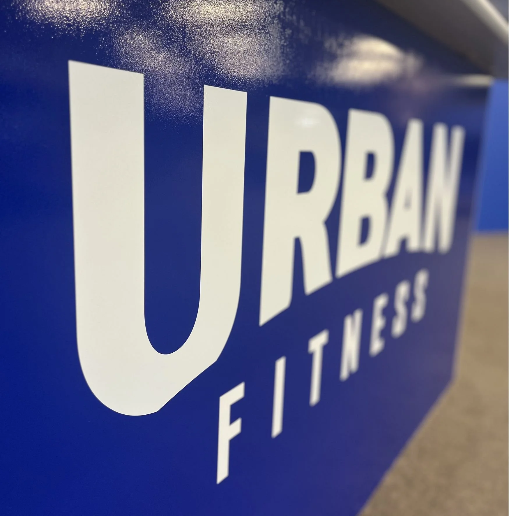 Close-up of a blue container with the white text 'URBAN FITNESS' printed on it.