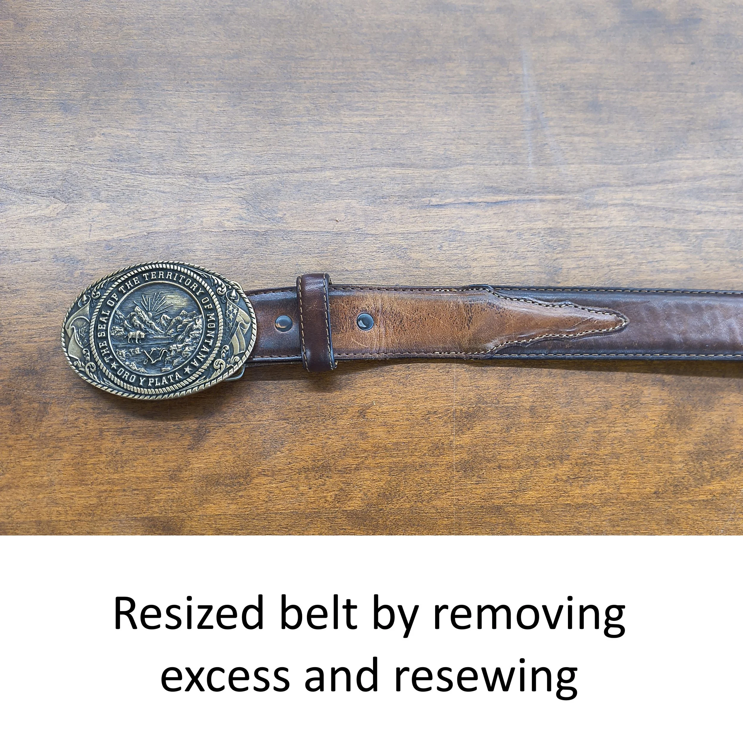 Close-up of a wooden surface with a sheriff's badge and a brown leather belt.
