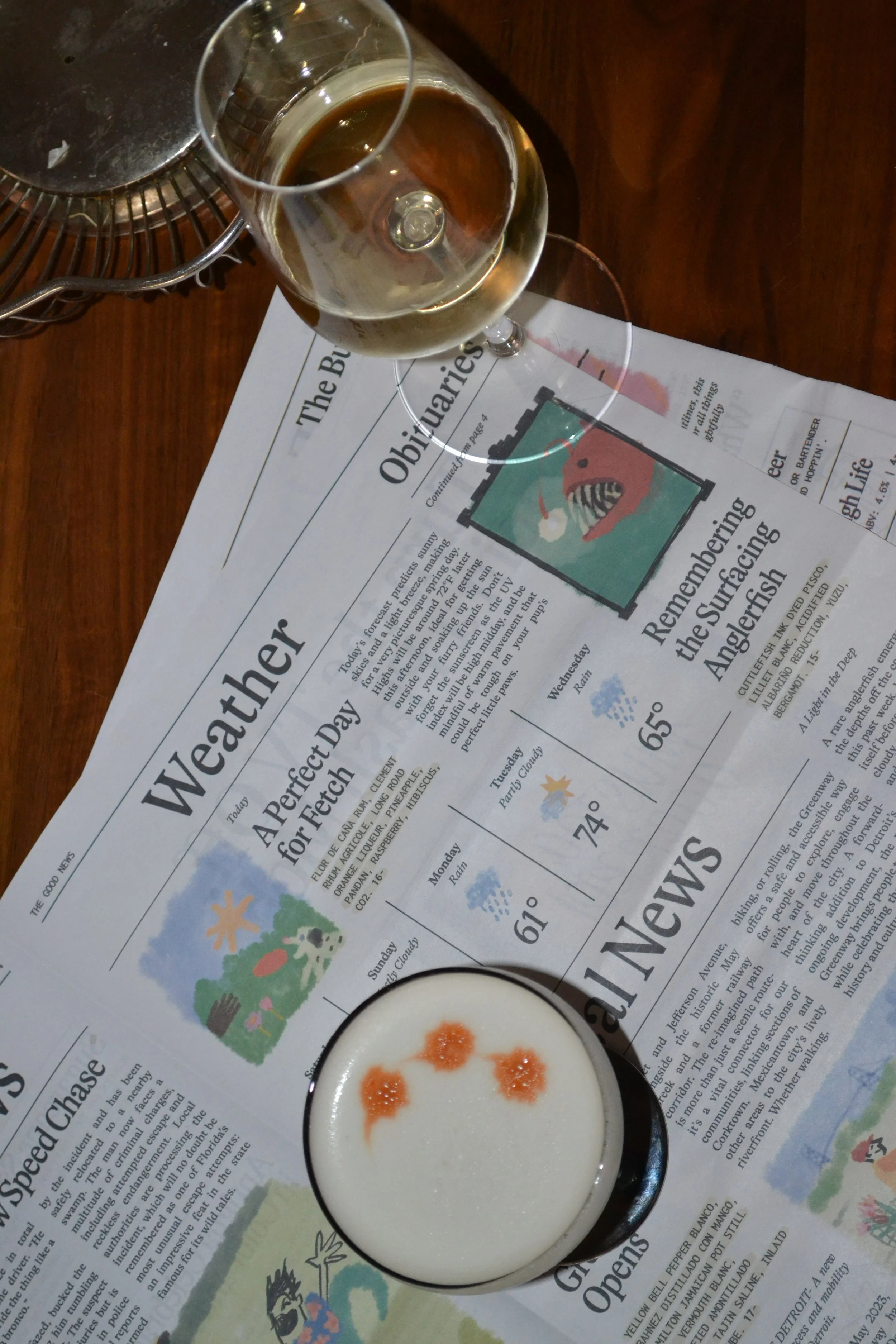 A glass of white wine and a whiskey sour on the Standby Good News page about weather and news.