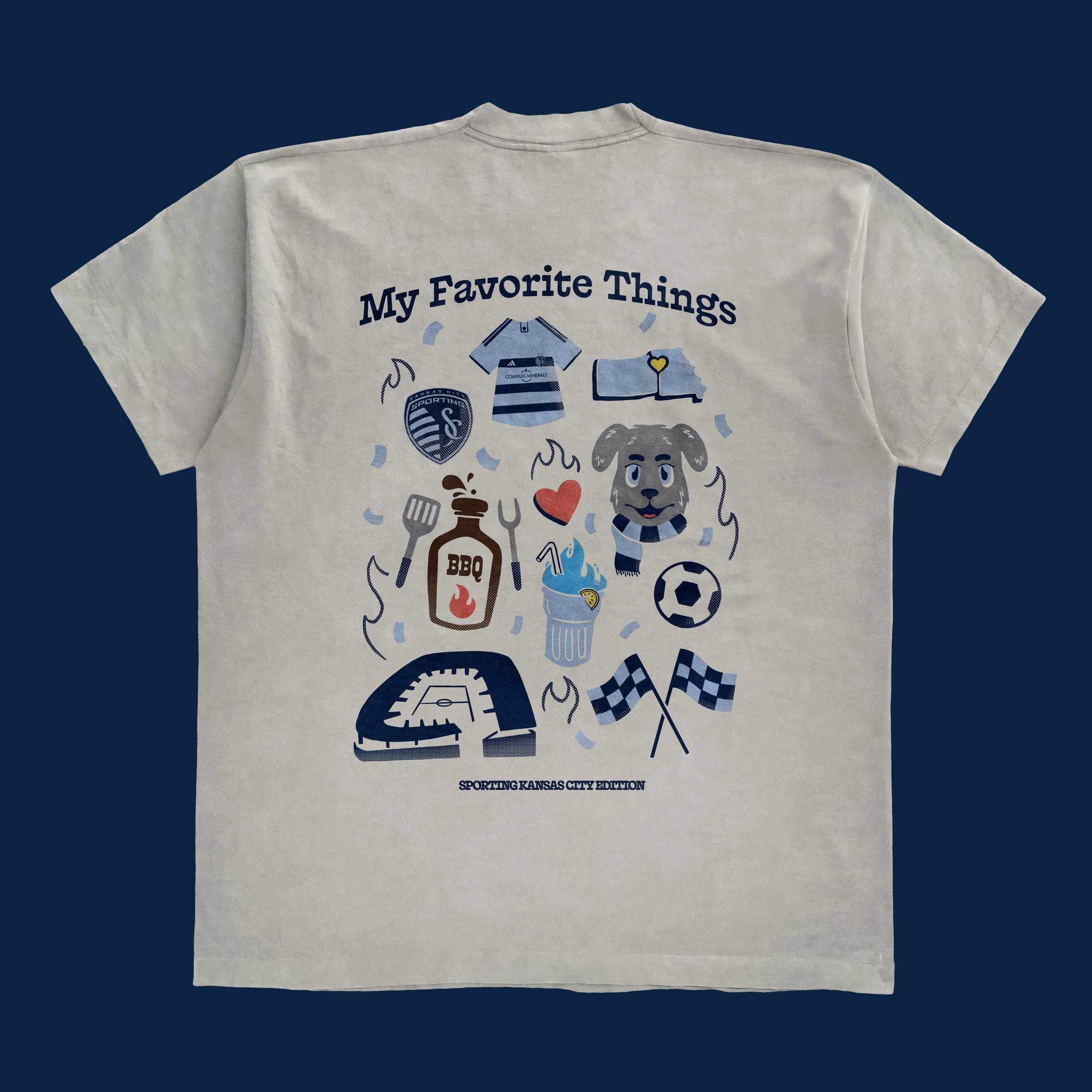 White T-shirt with illustrations of sports items, food, and a dog, labeled "My Favorite Things," including a soccer ball, a rugby jersey, a flag, a barbecue sauce bottle, a drink, a football stadium, and two checkered flags, with text "Sporting Kansa