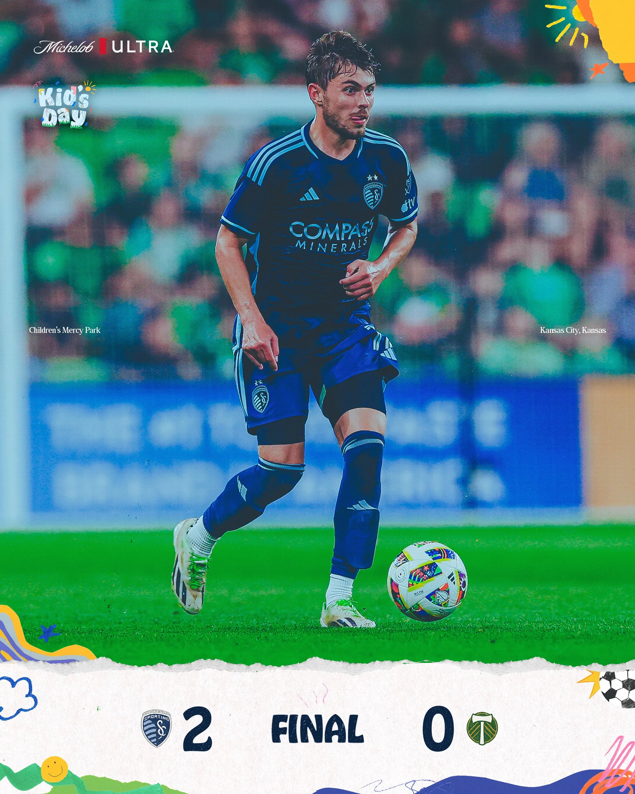 A male soccer player in a blue jersey with the logo of Sporting Kansas City, kicking a soccer ball during a game at Children's Mercy Park, with the final score 2-0 in favor of Sporting Kansas City, against Portland Timbers.