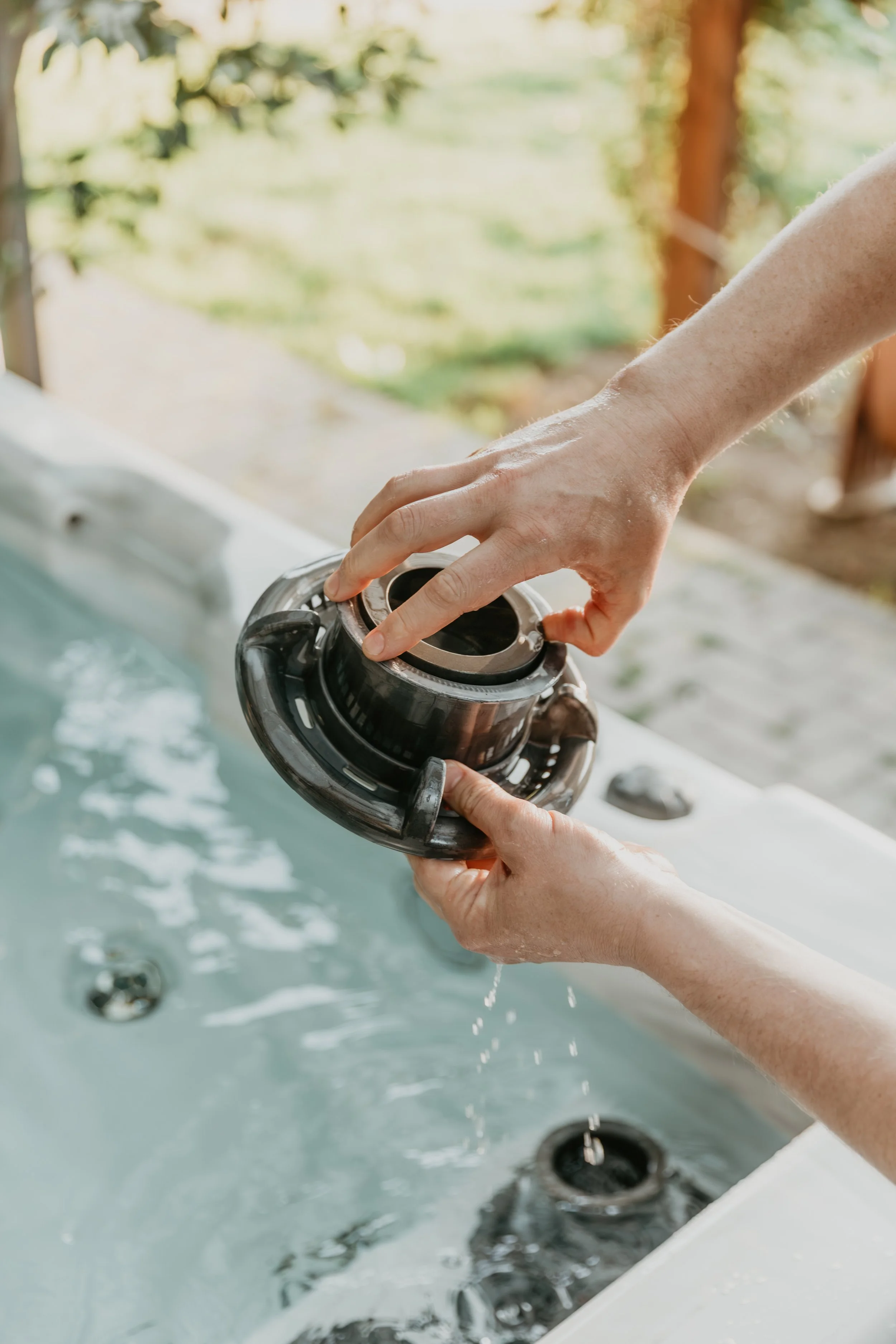 Person placing a robotic spa jet into hot tub or spa..