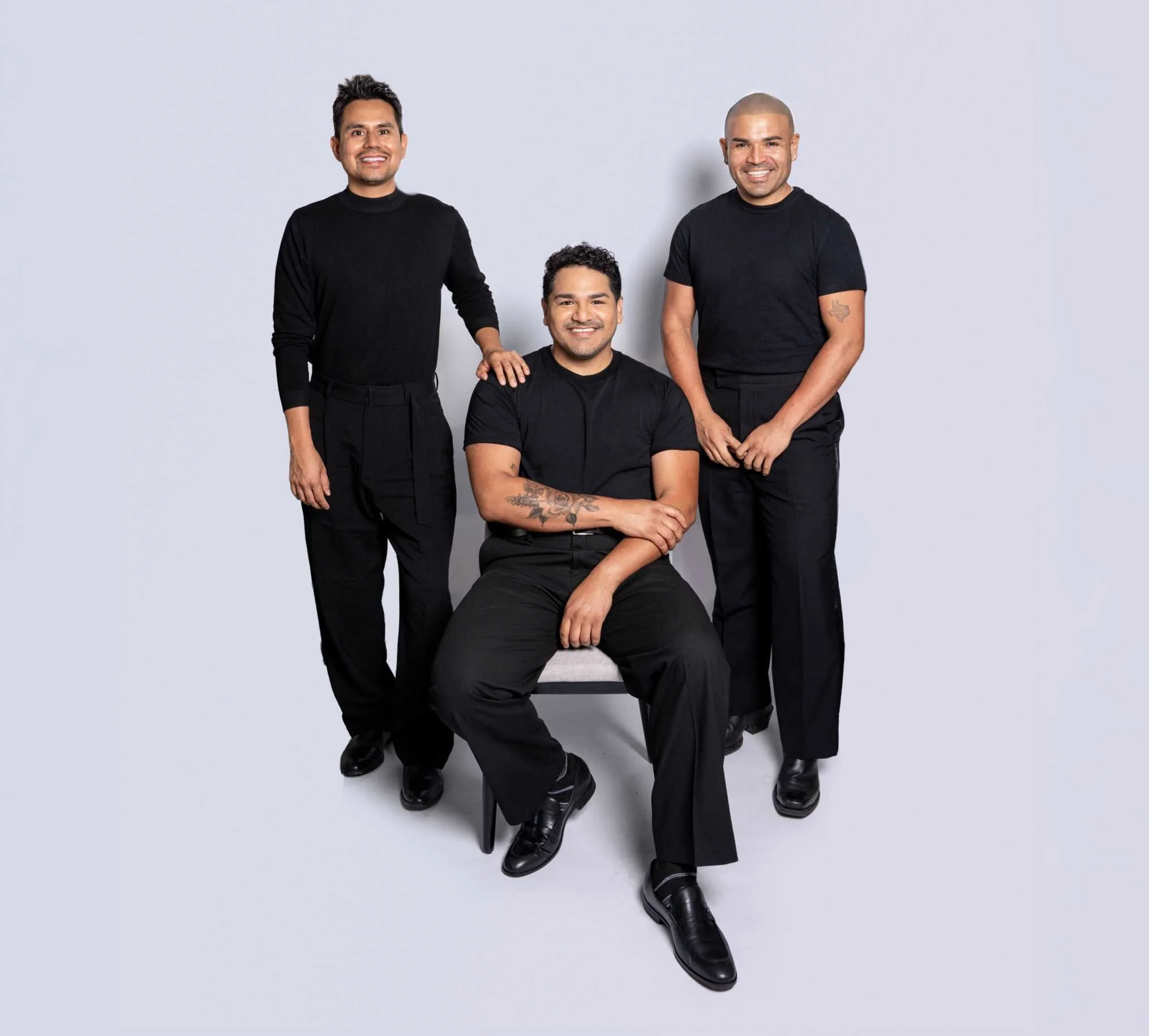 Three members of the Pueblo Collective team posing together in coordinated black attire