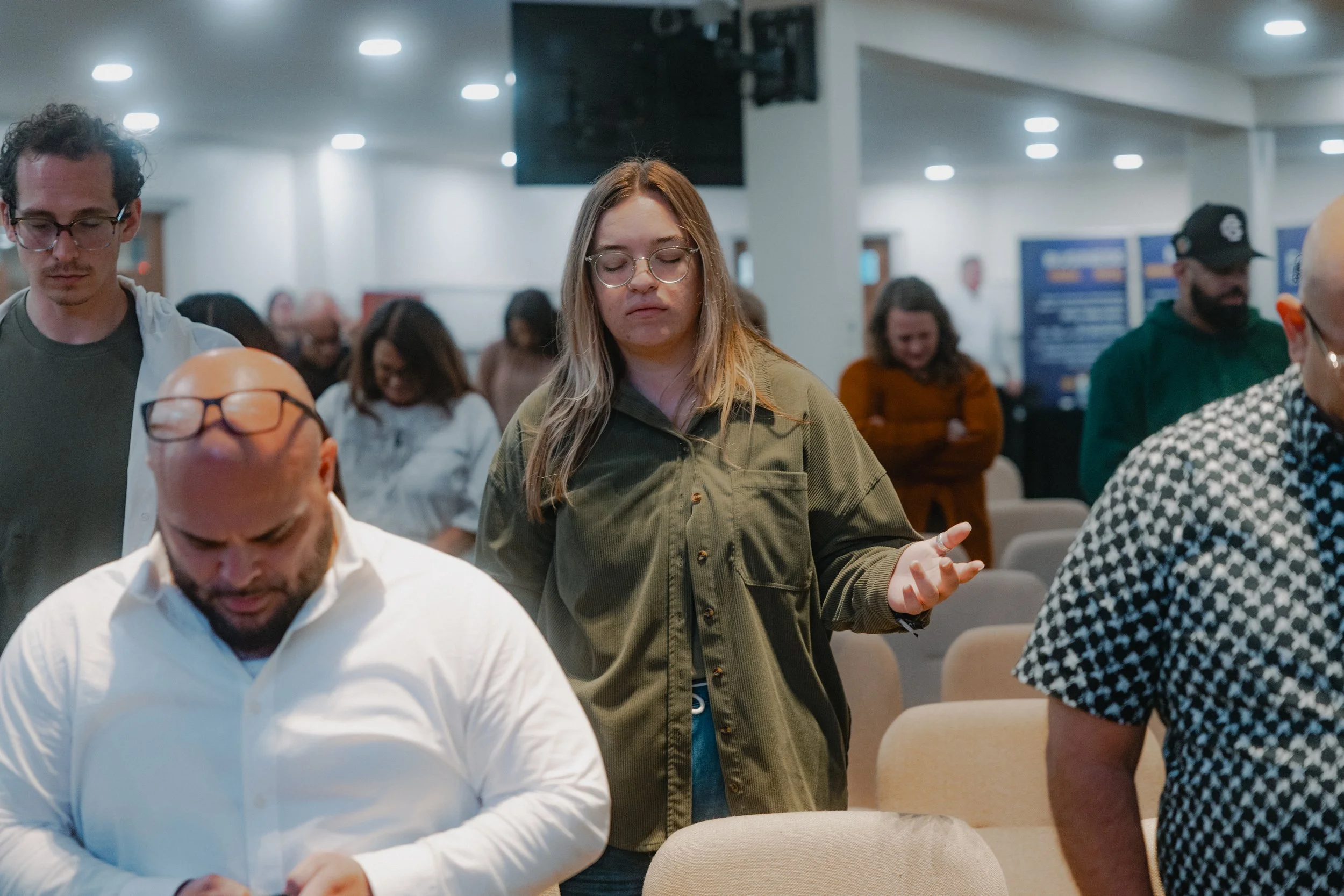 People praying and worshipping in a church or prayer room.