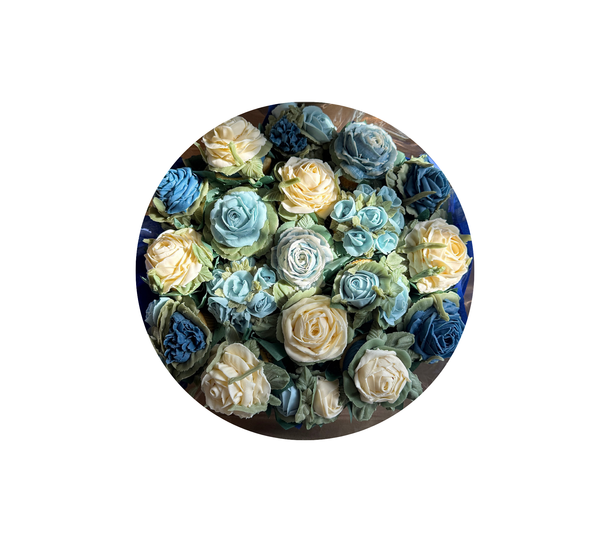 A bouquet of floral cupcakes in various shades of dark blue, light blue and cream.