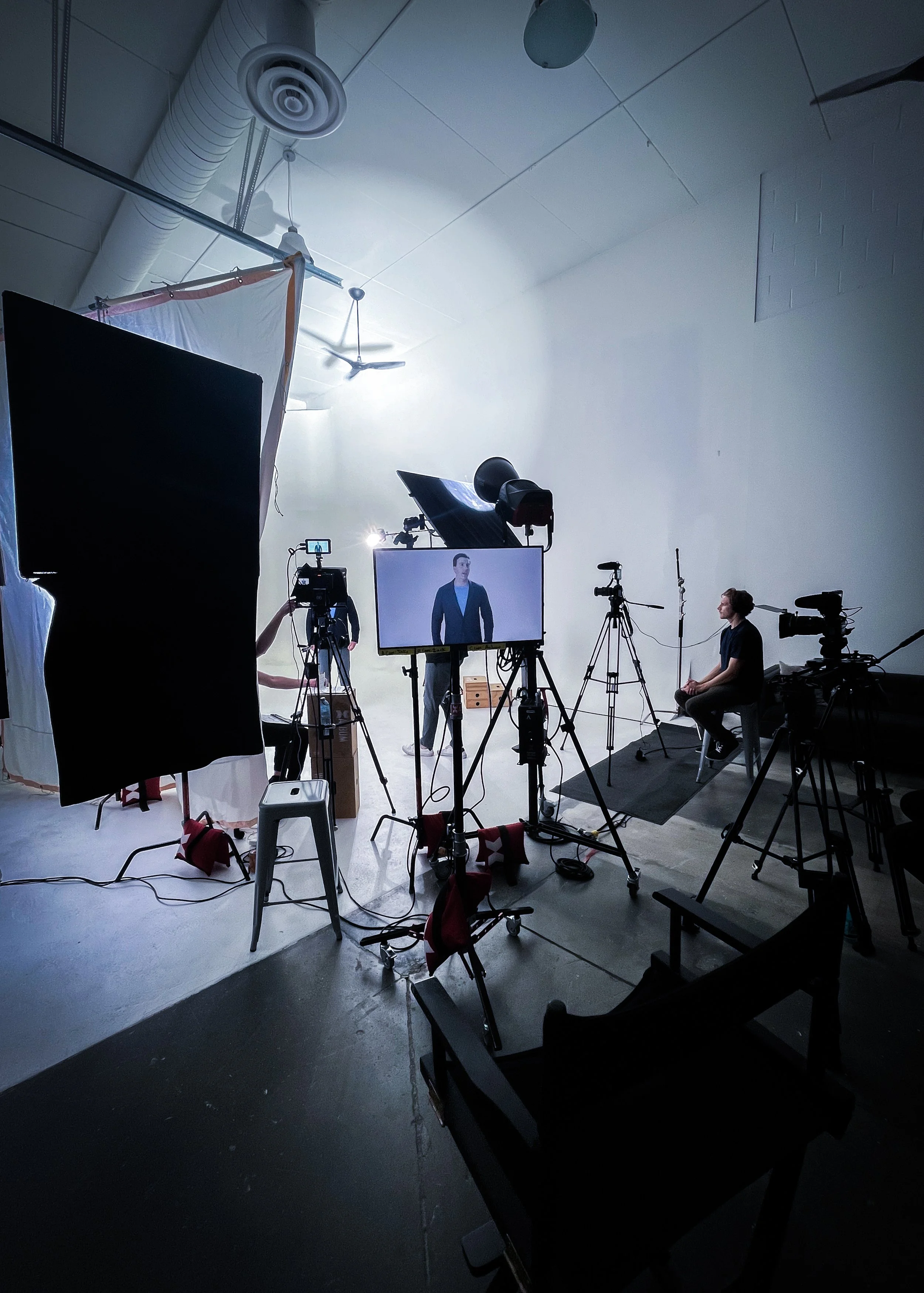 Full video production studio setup with lighting, cameras, and monitor during a commercial shoot