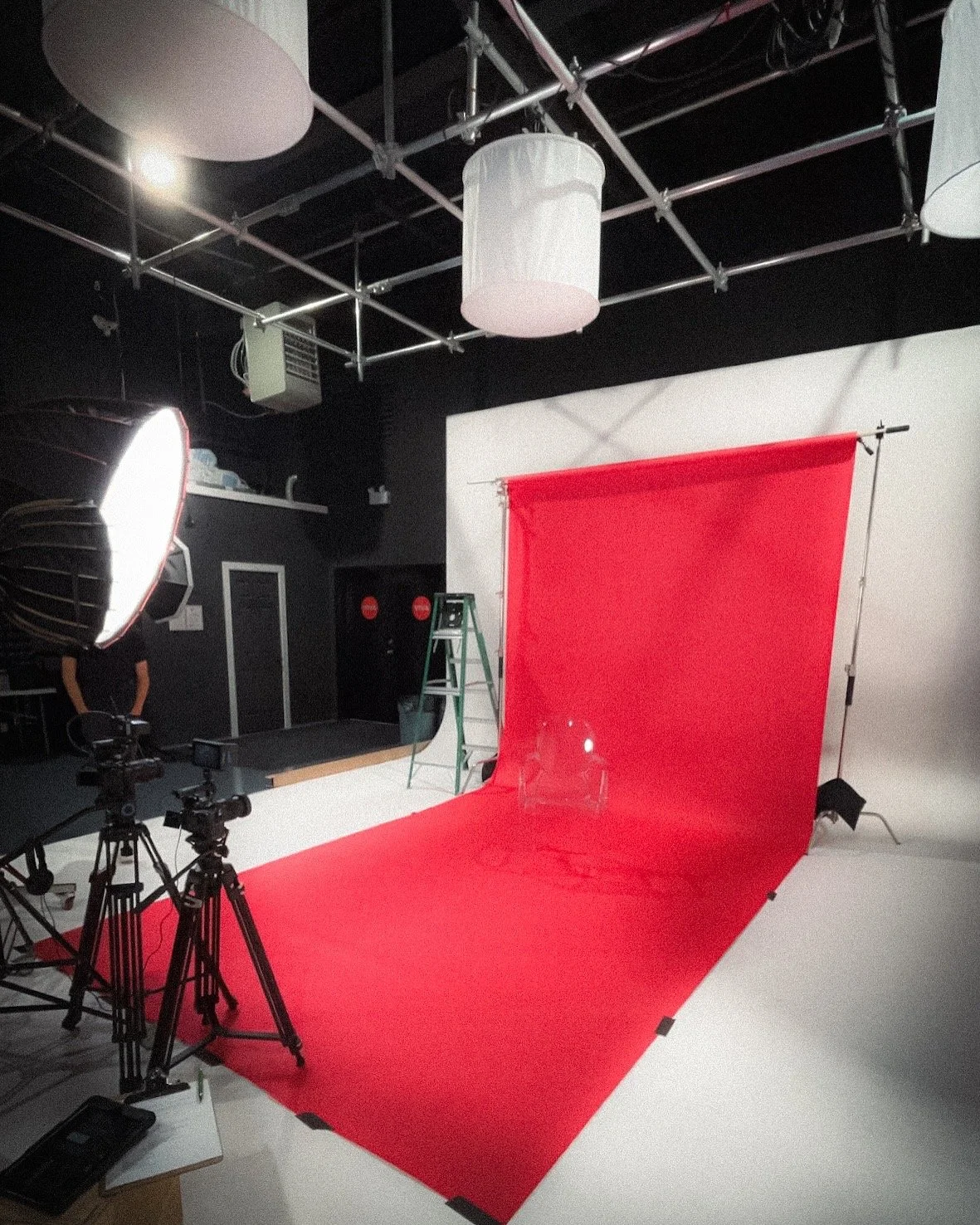 Professional studio setup with red backdrop and lighting for video and photo content production