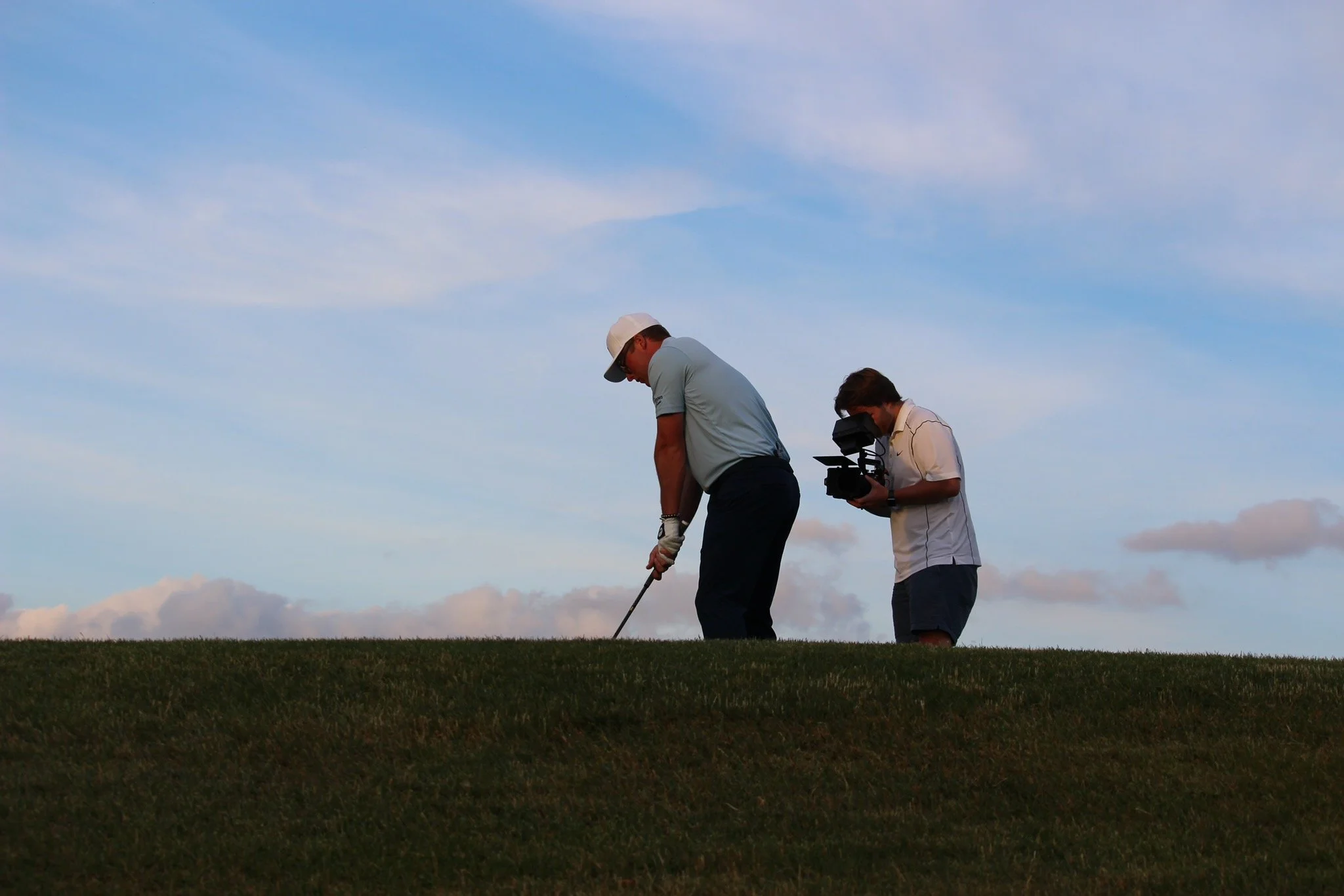 Videographer filming golf content for a branded sports video production shoot