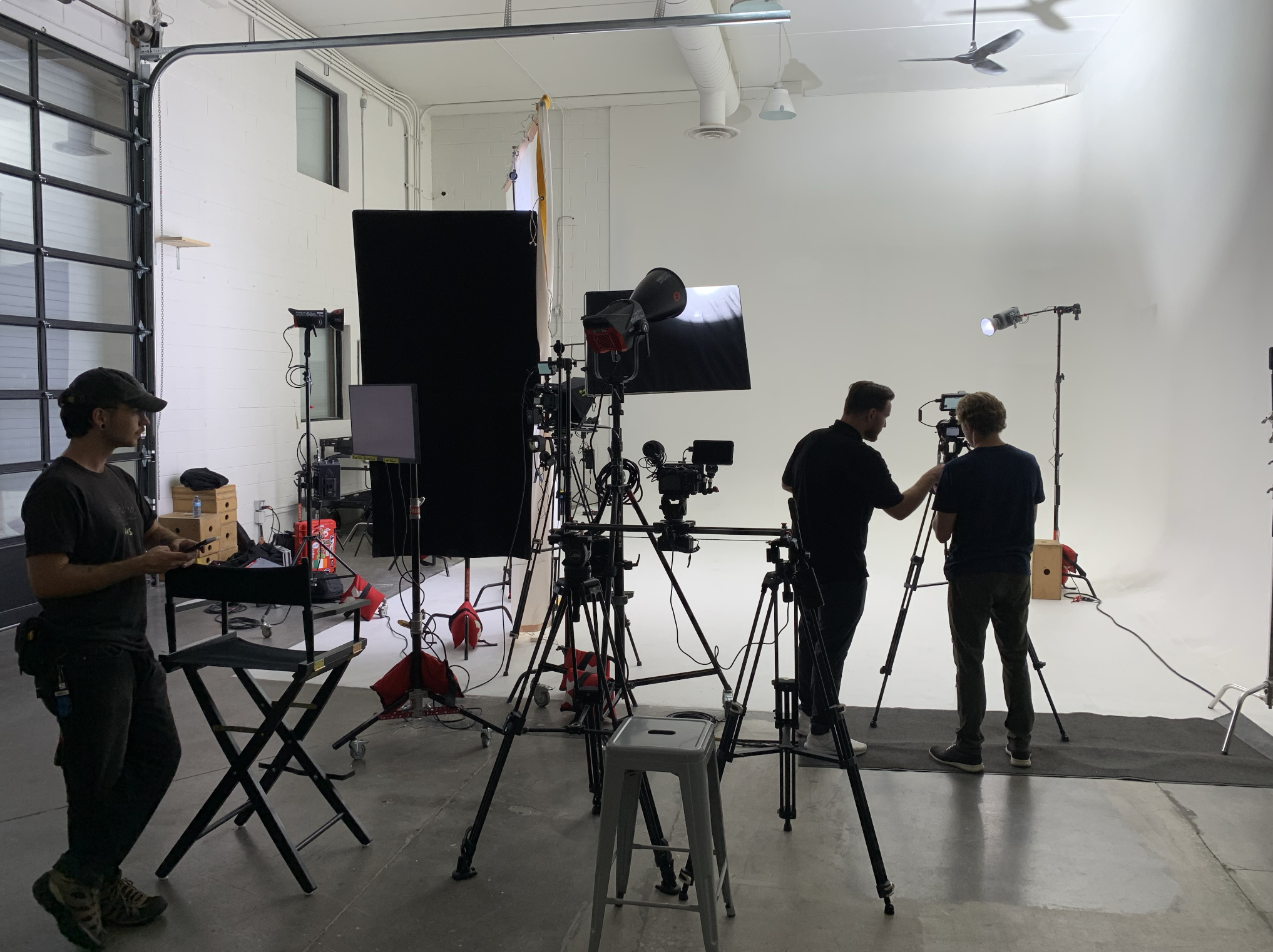 Professional video production studio setup with cameras, lighting, and crew preparing for a commercial shoot